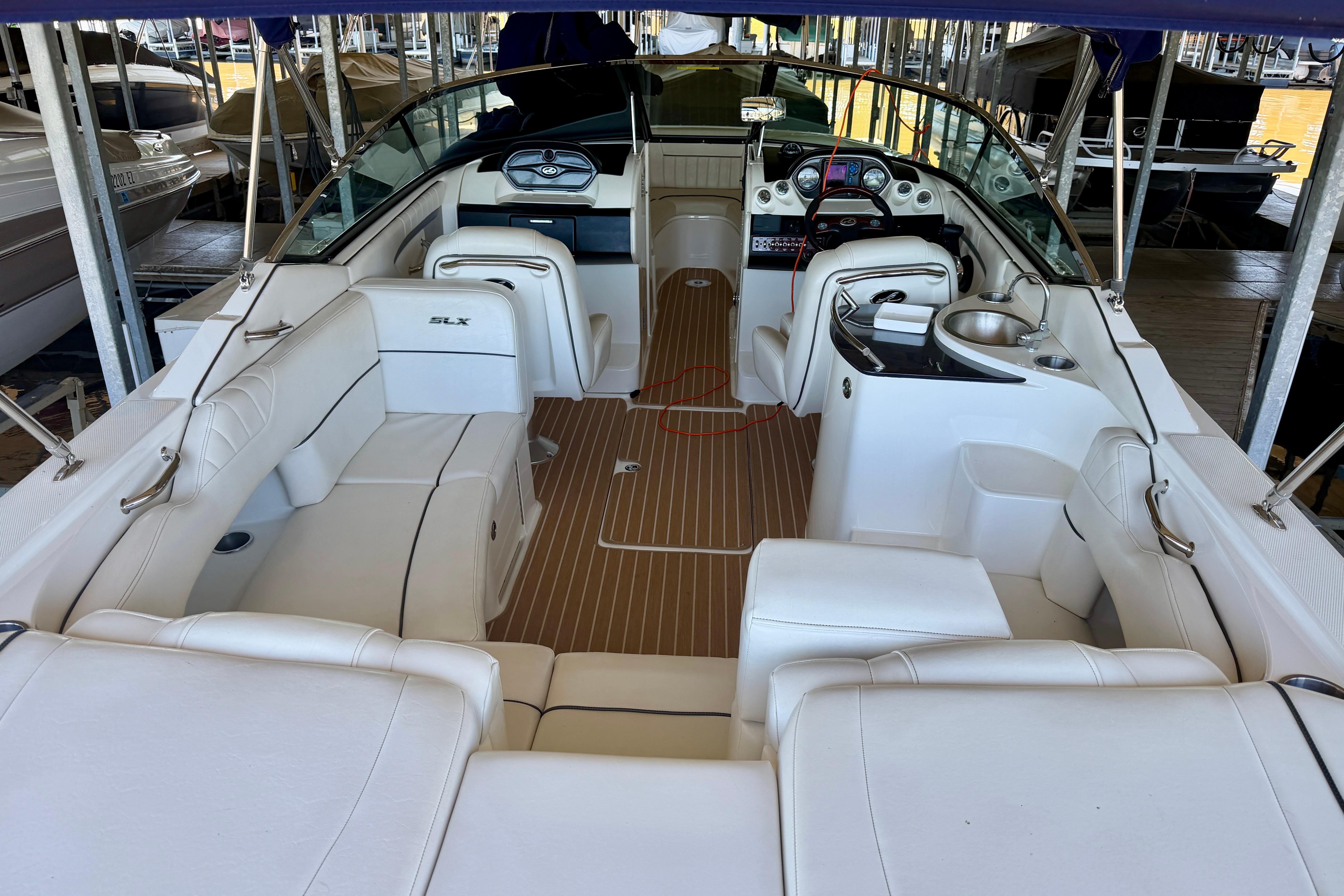 2007 Sea Ray 270 SLX boat interior with white seating and wooden flooring.