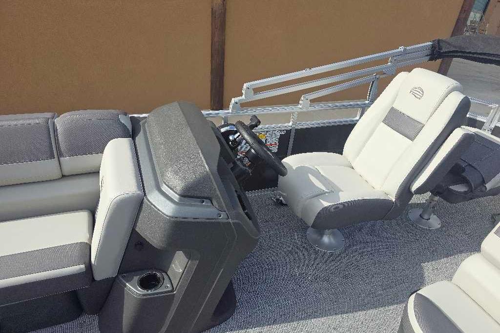 2026 Sun Tracker Fishin' Barge 20 DLX interior with plush seating and modern helm.