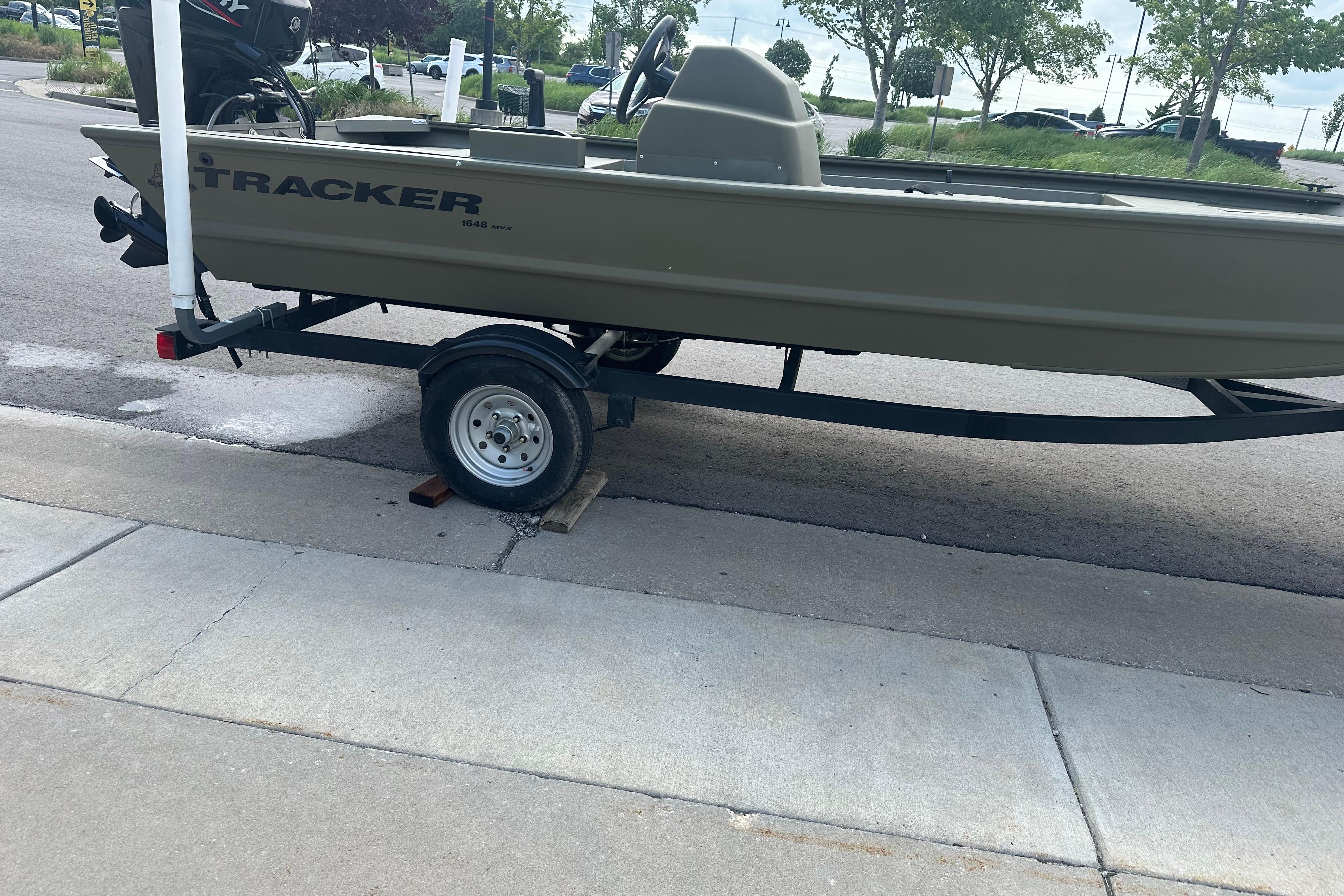 2024 Tracker Grizzly 1648 SC boat on trailer, parked on a street.