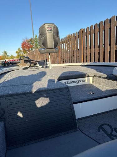 2025 Ranger ALPHA 208 boat deck with seating, against a wooden fence backdrop.