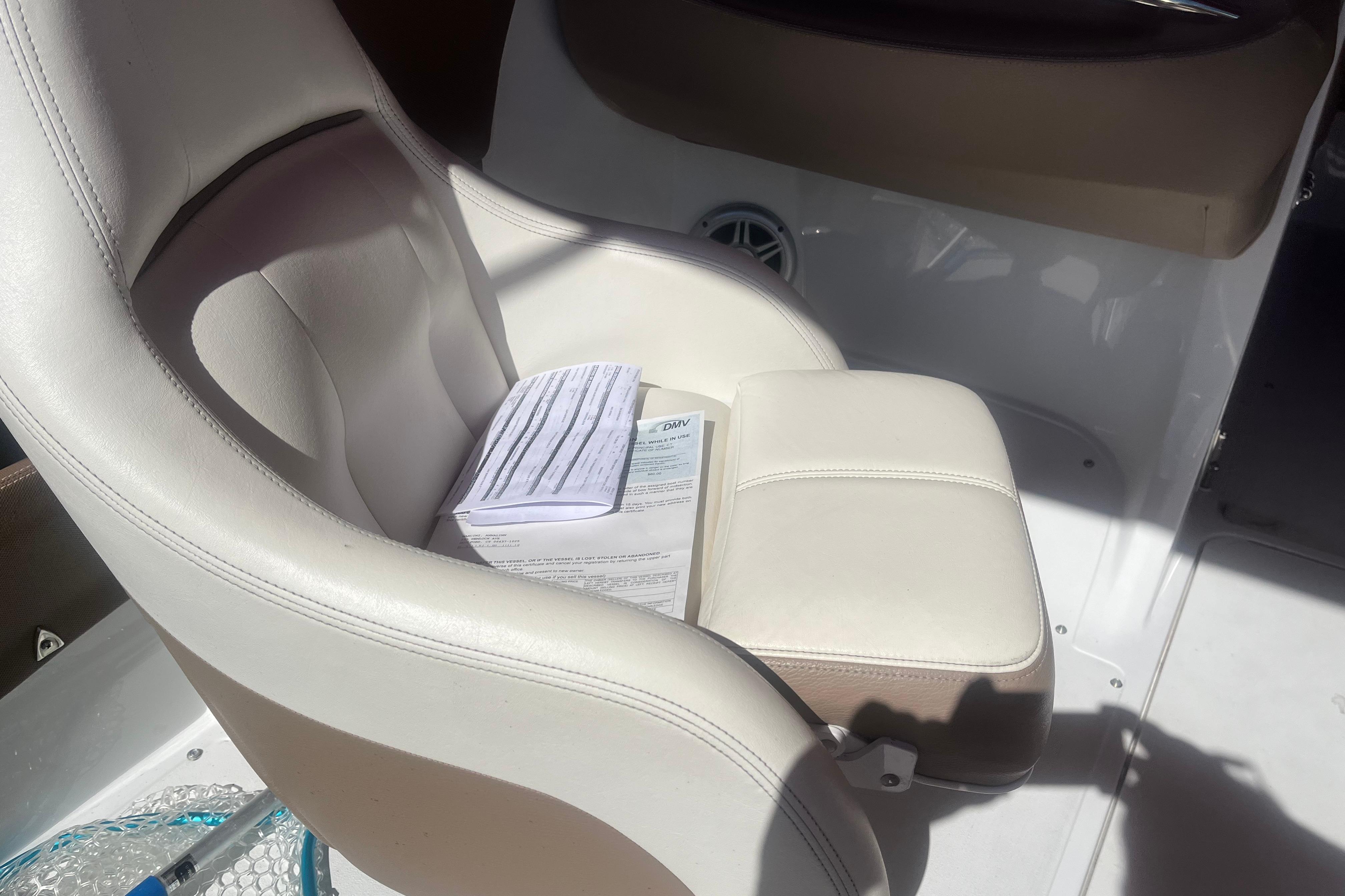 White leather seat in a 2011 Cobalt 210 boat with documents placed on it.