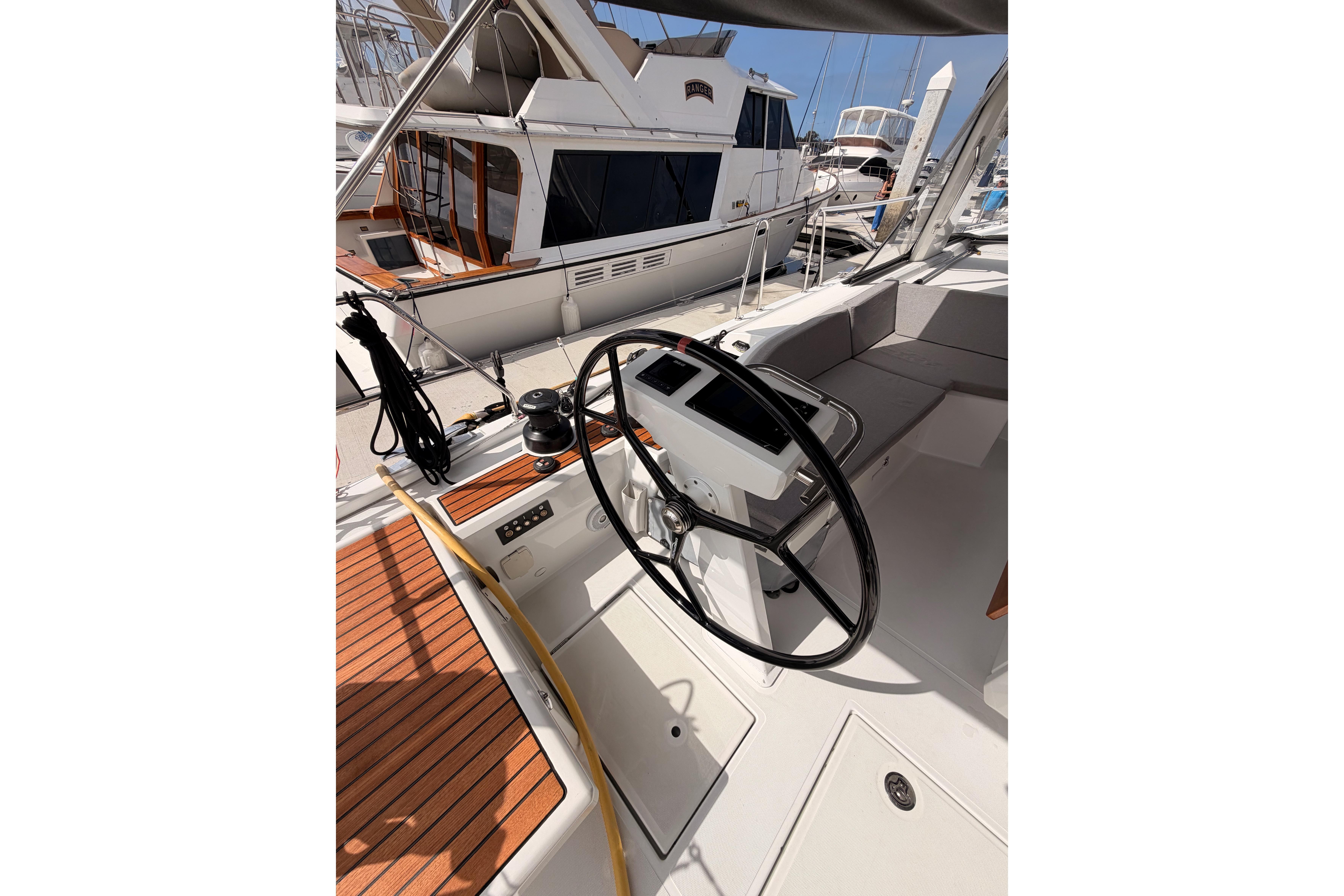 Cockpit of 2020 Beneteau Oceanis 46.1 yacht with steering wheel and teak decking.