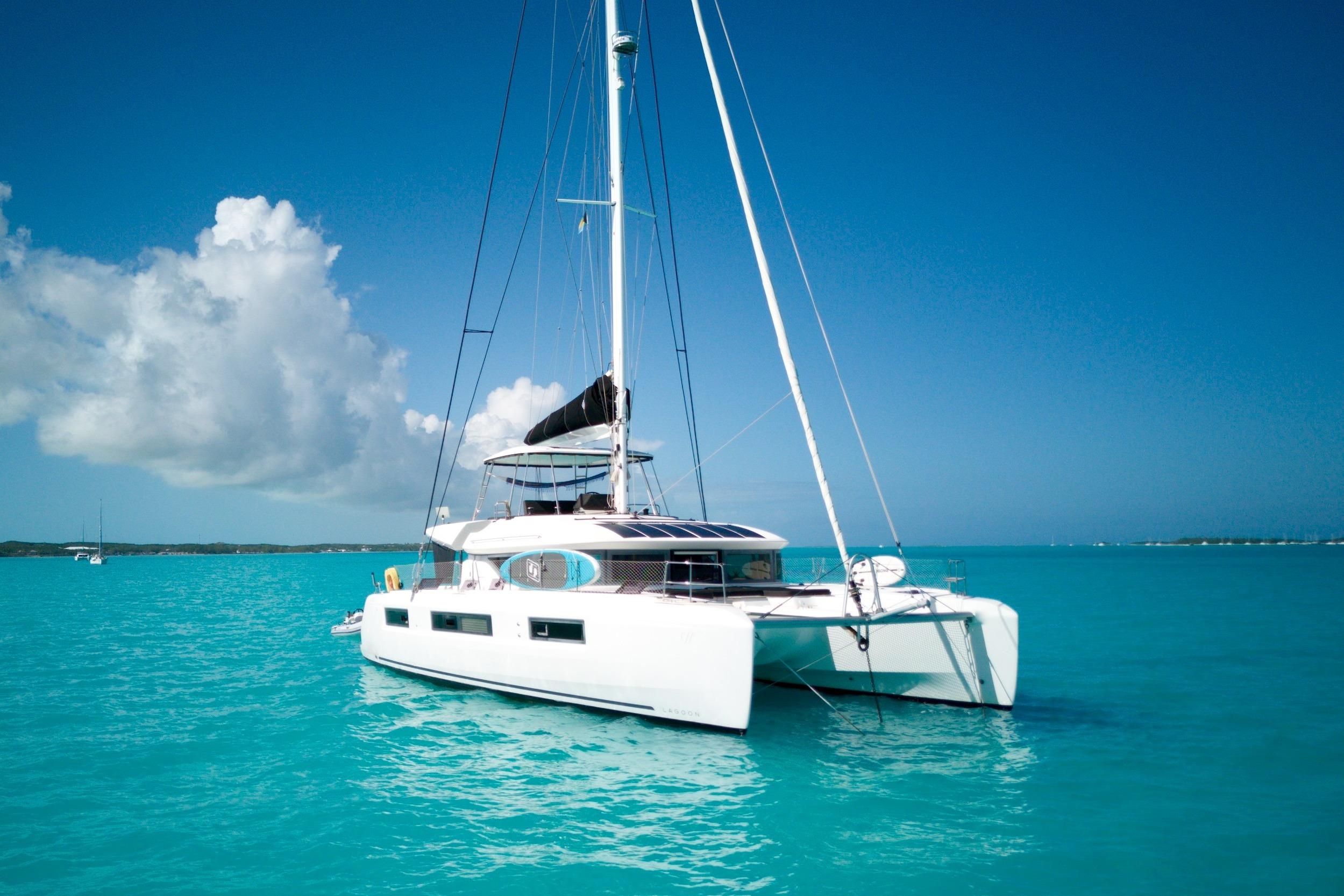 2023 Lagoon 50 catamaran sailing on turquoise waters under clear blue sky.