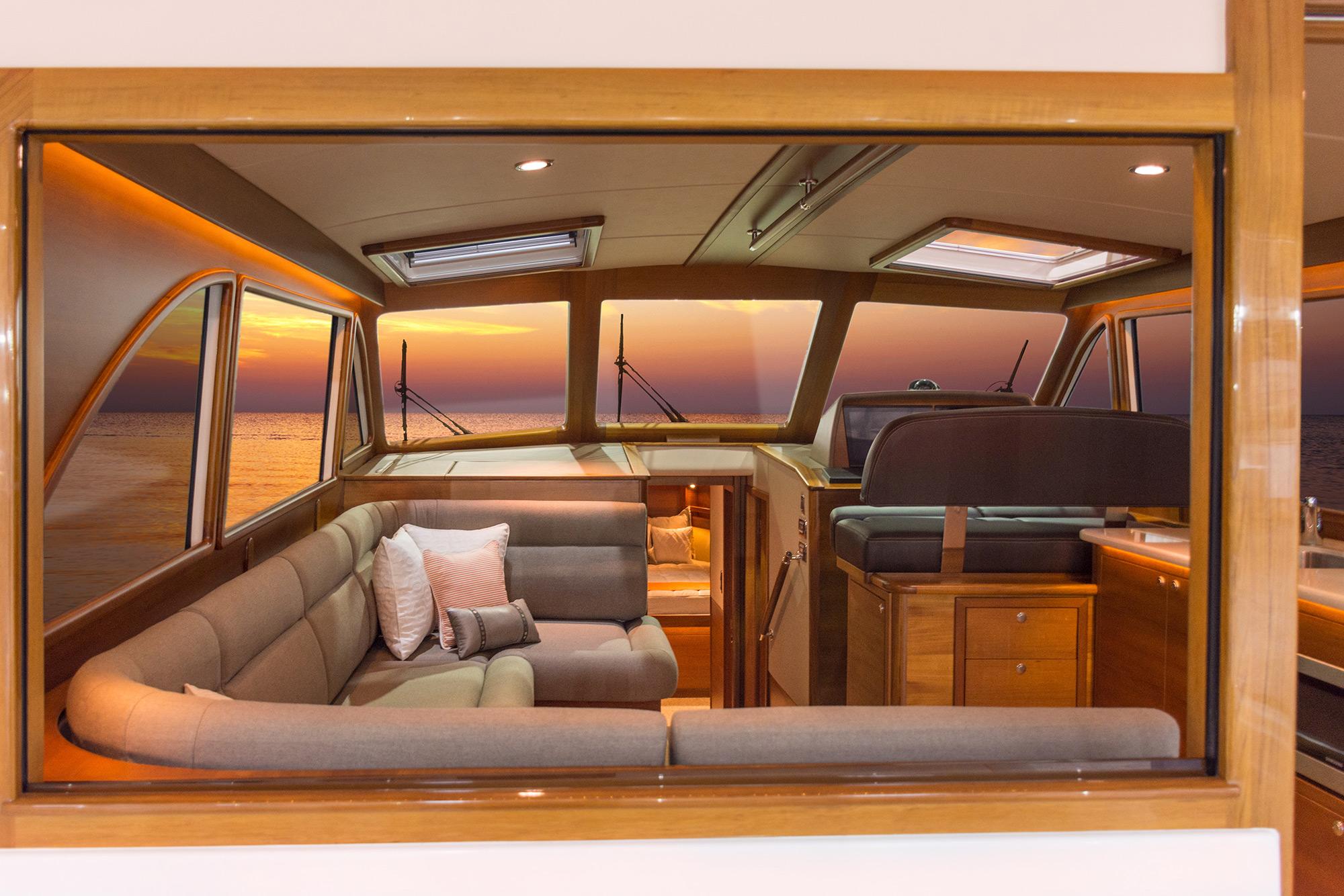 Luxurious Eastbay EB44 yacht interior with sunset view, featuring plush seating and elegant wood finishes.