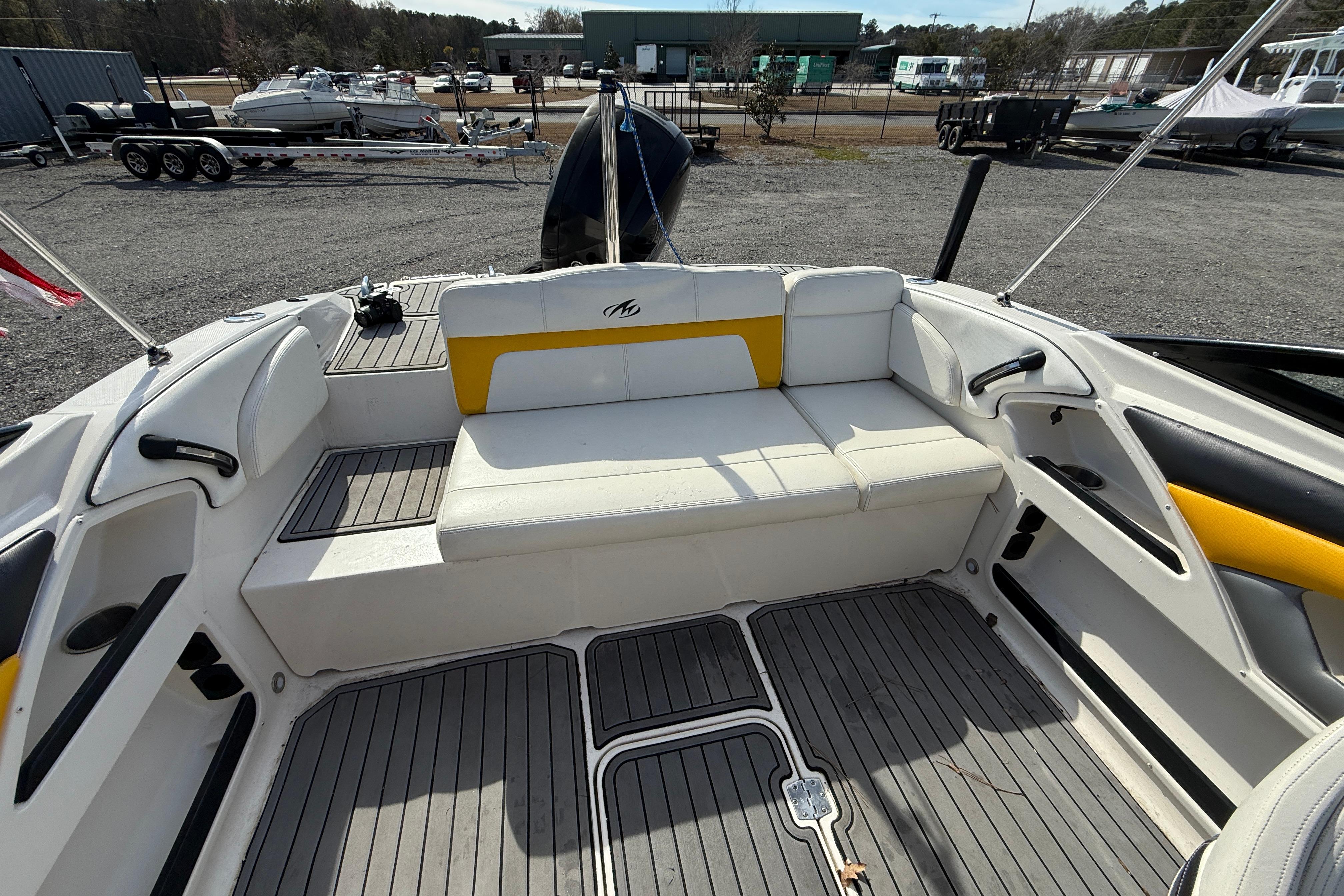 2014 Monterey 197 Blackfin boat interior with white and yellow seating, docked outdoors.