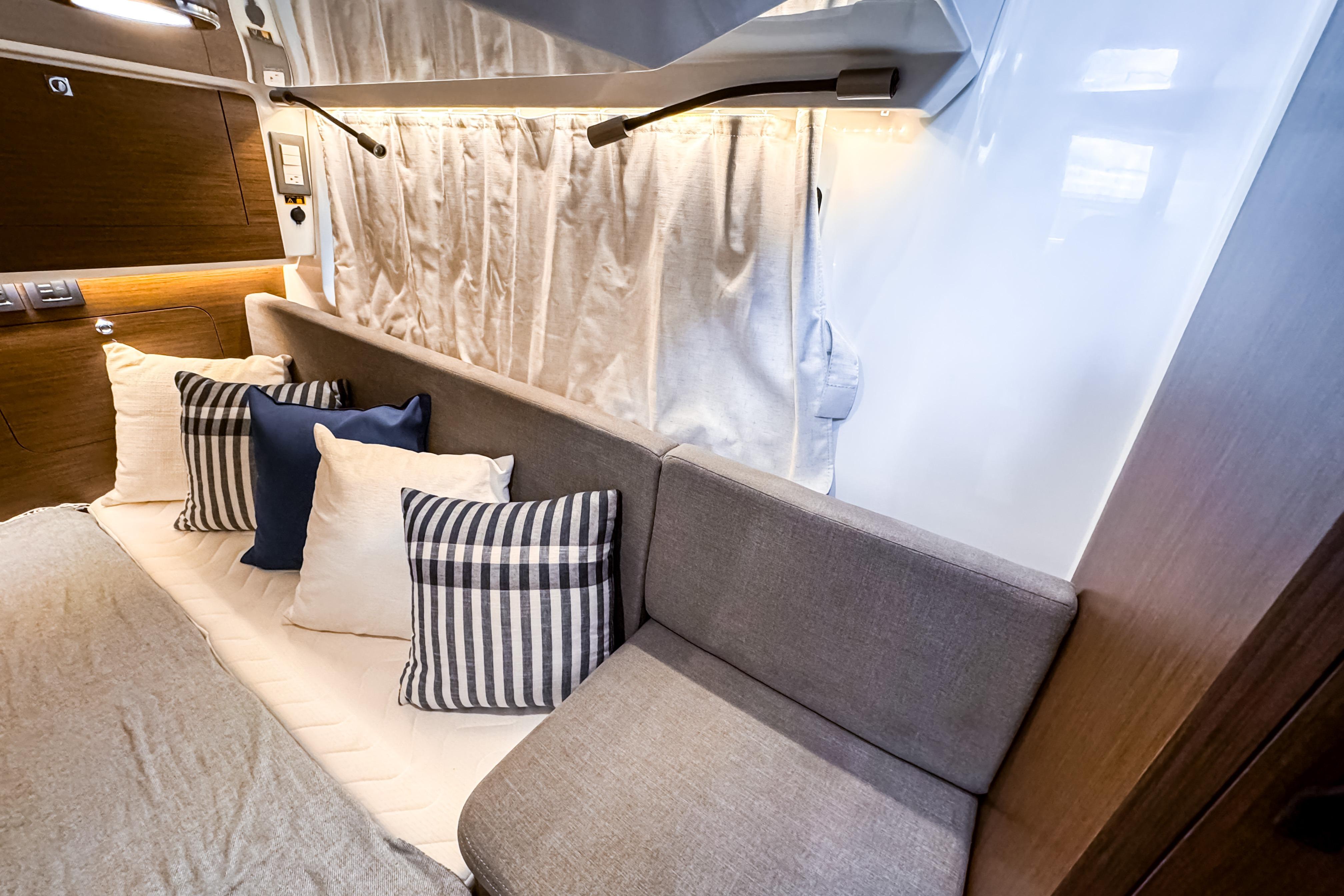 Interior of 2026 Beneteau Antares 11 with cozy seating and decorative pillows.
