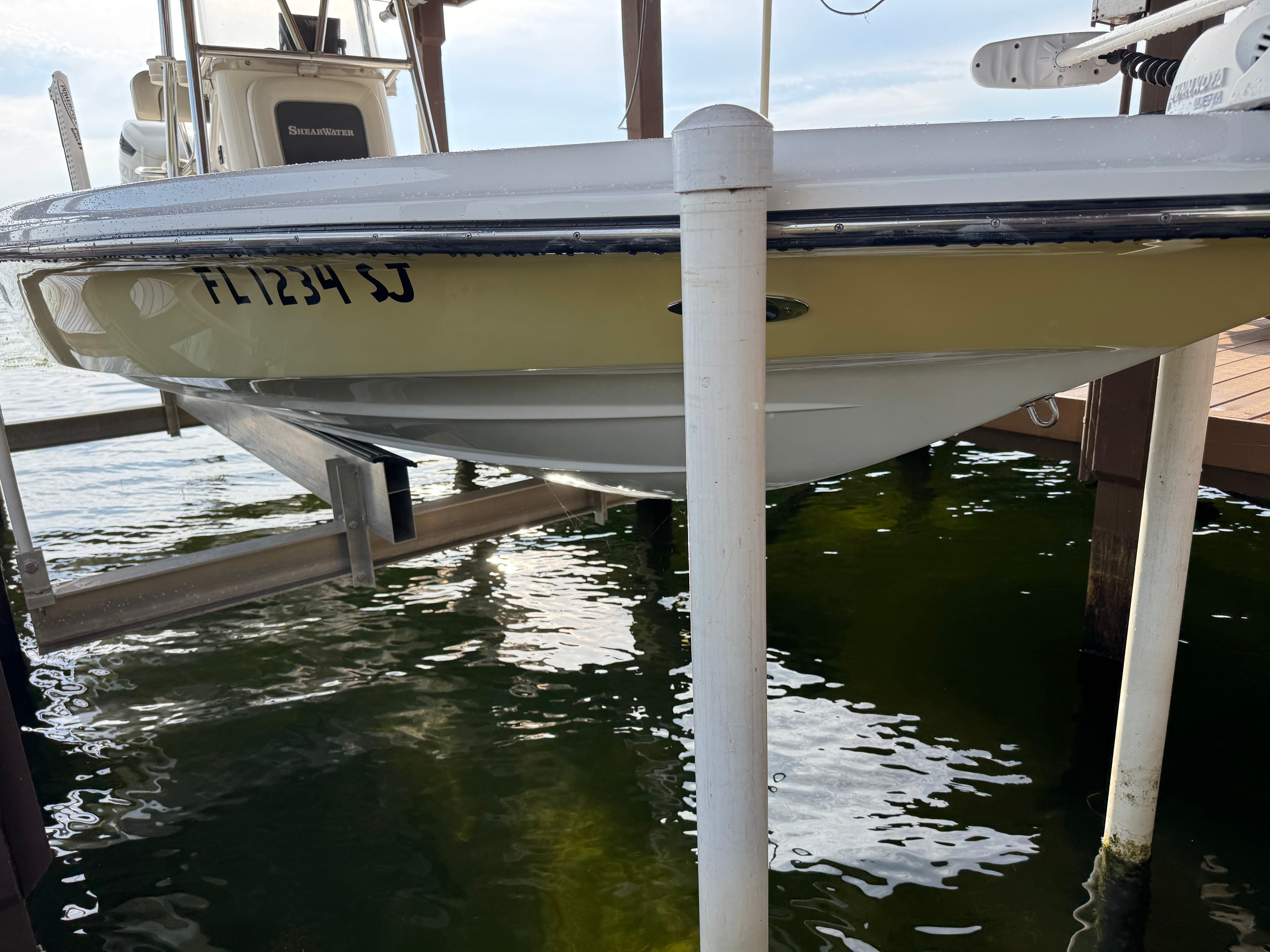 2004 ShearWater LTZ boat on a boat lift by the water.