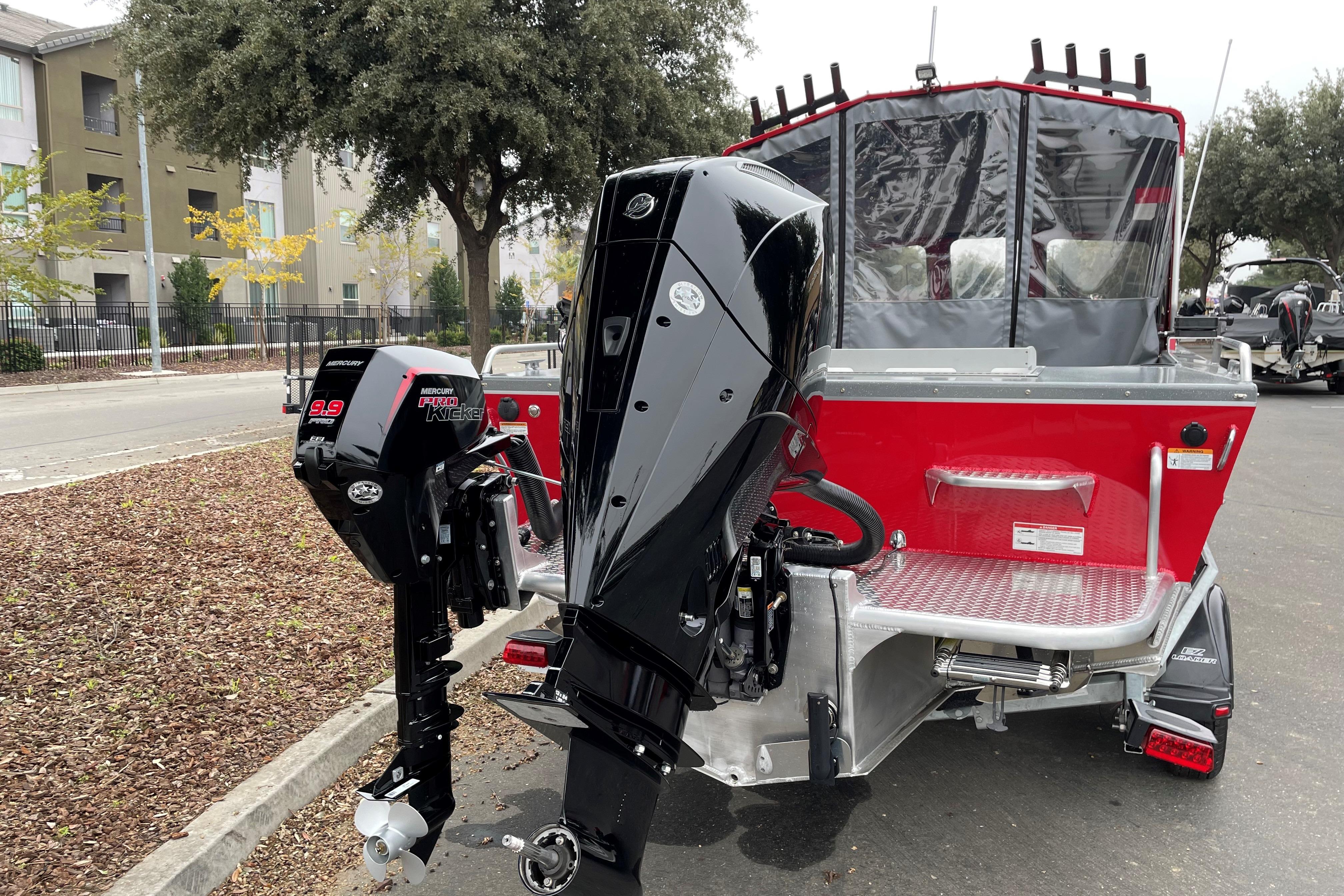 2024 Spartan 200 Astoria boat with powerful outboard motors, parked on a street.