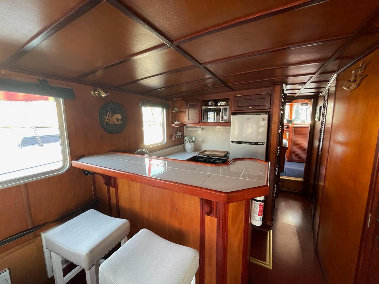 Interior of a 2010 Custom Trawler with wooden decor and a compact kitchen area.