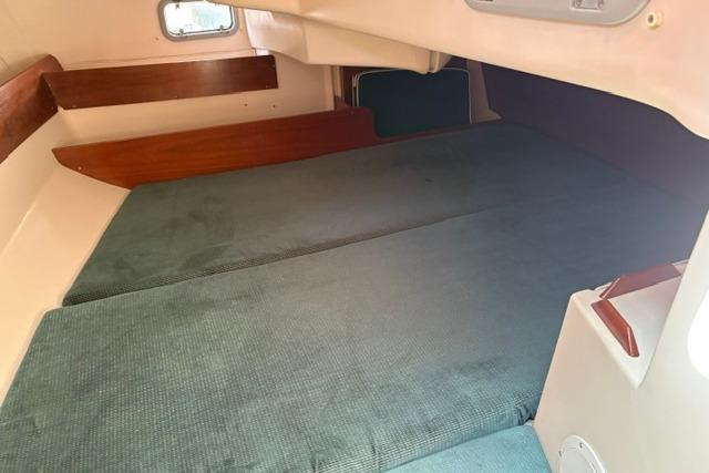 Interior cabin of 2000 Beneteau Oceanis 321 sailboat with green cushions.