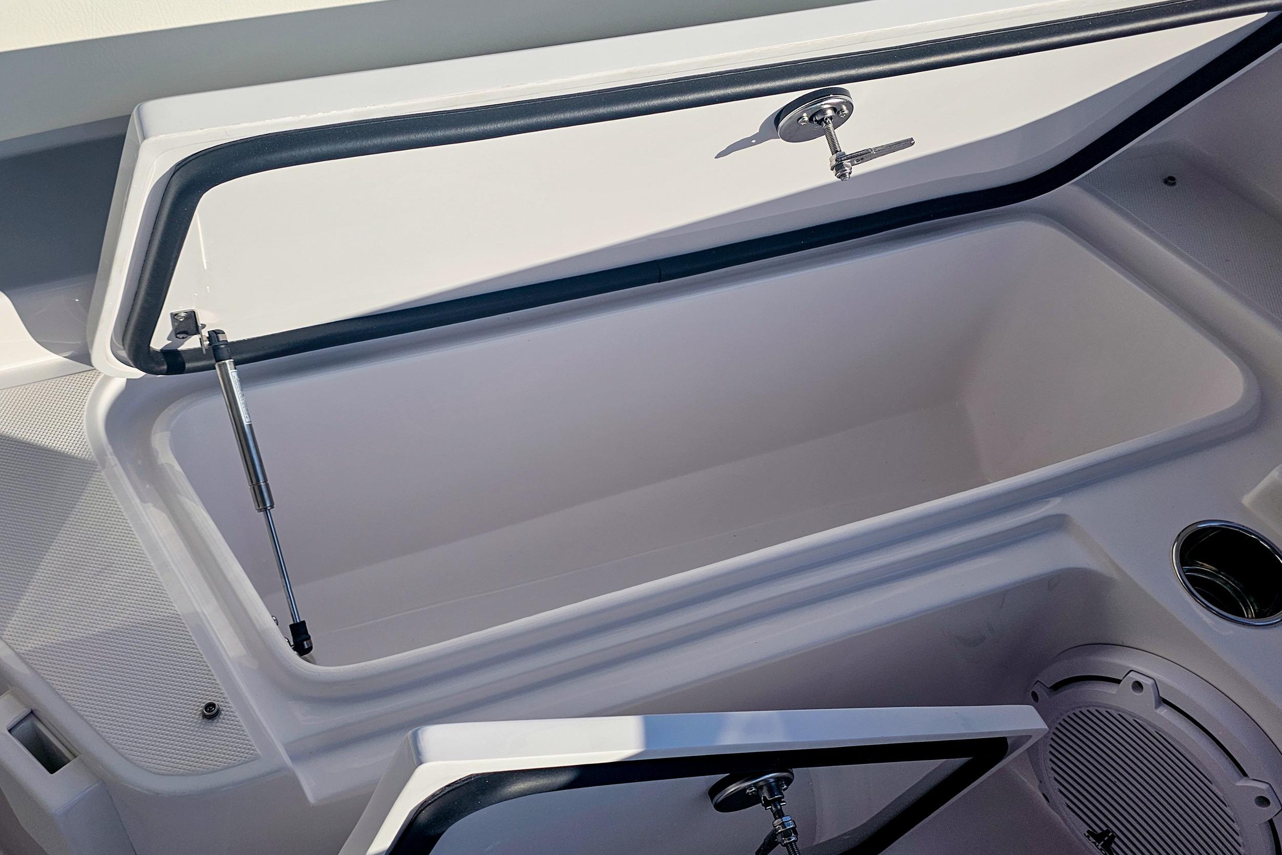 Open storage compartment on a 2026 Jupiter 26 boat, featuring sleek design and modern hardware.