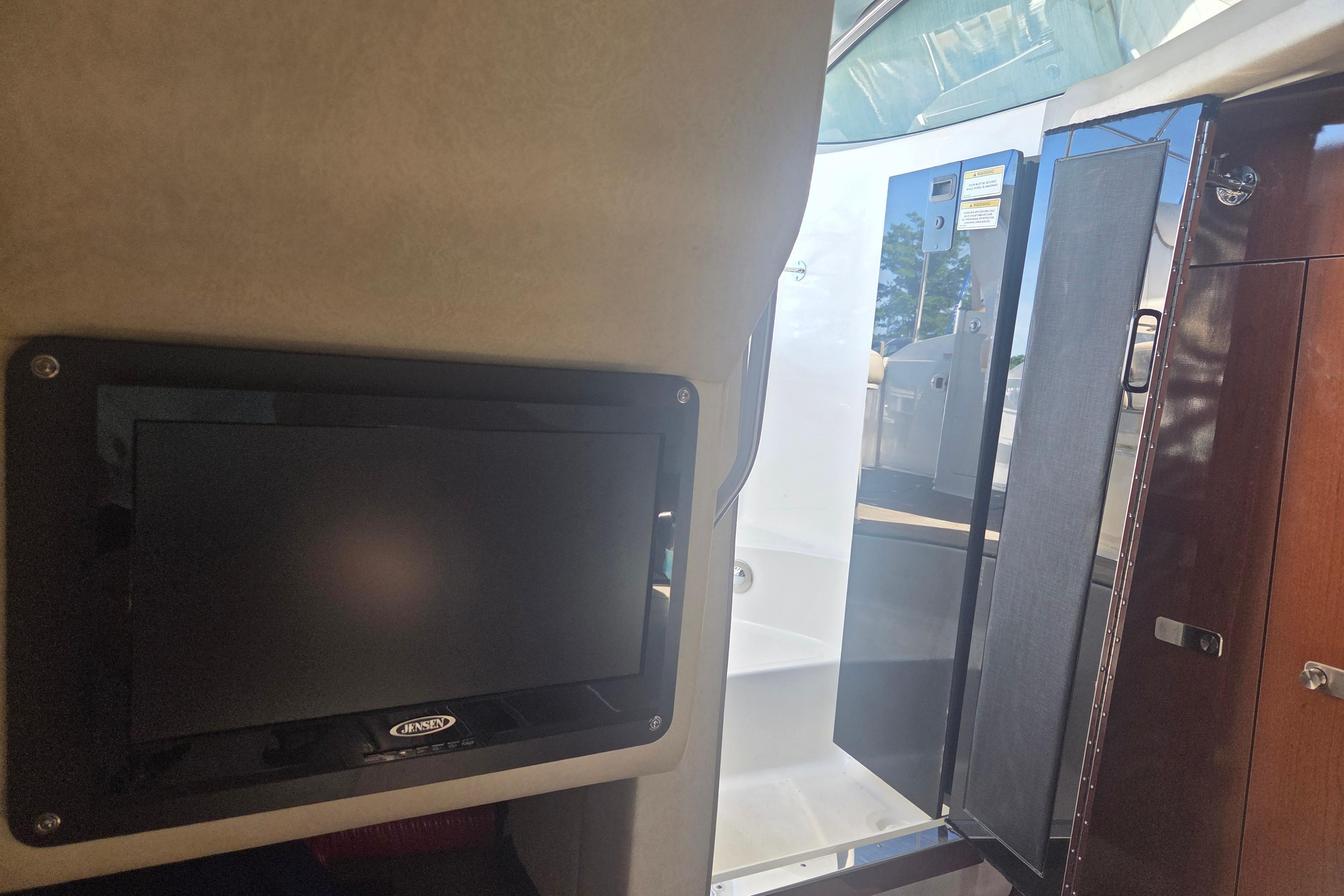 Interior view of 2012 Sea Ray Sundancer 260 with TV and cabin door.