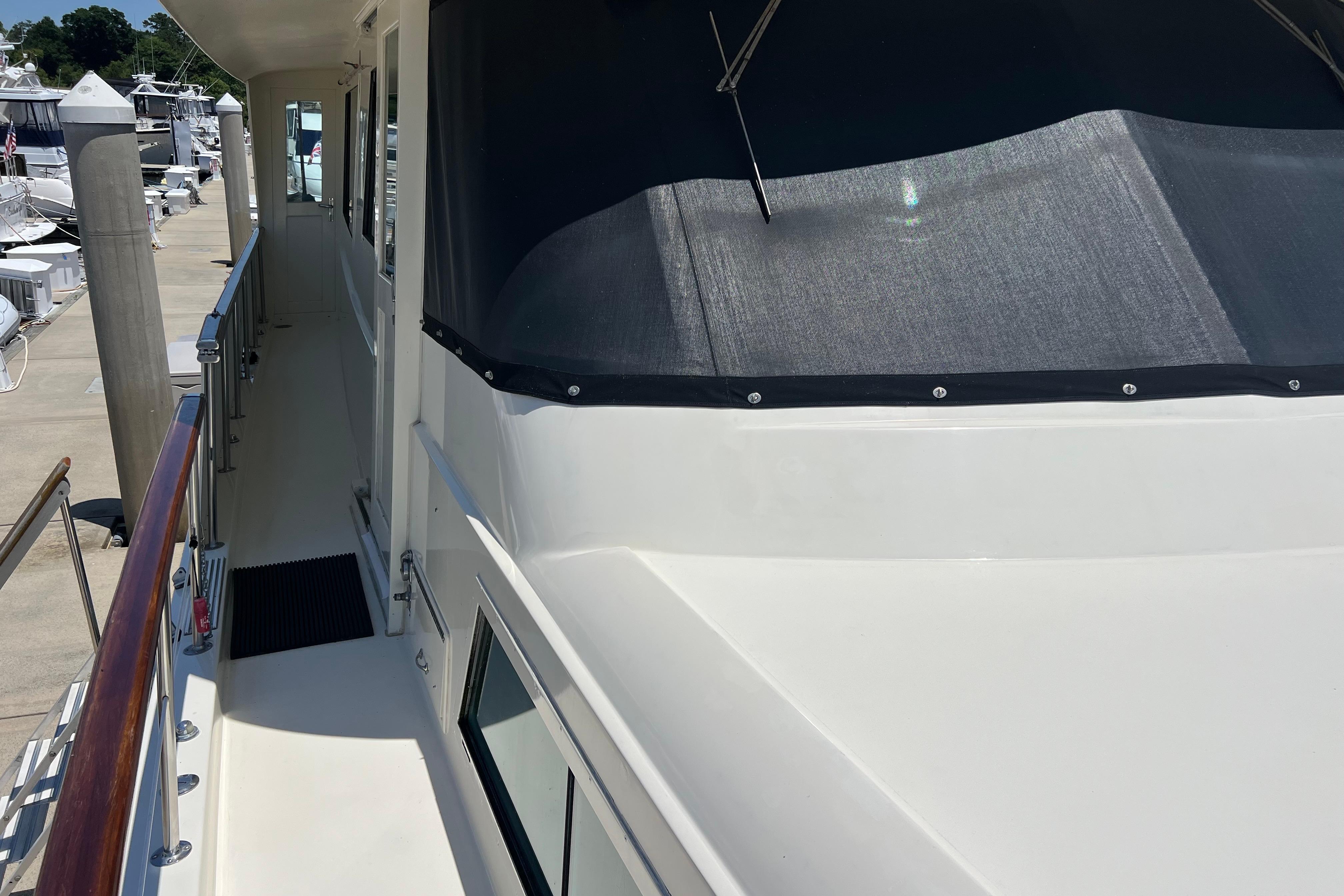 1987 Hatteras 70 Cockpit Motor Yacht docked, showcasing sleek exterior and walkway.
