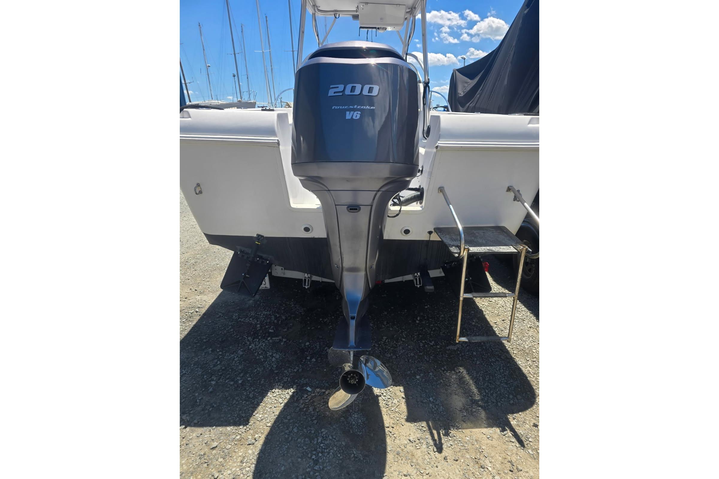 2003 Pro-Line 22 Walkaround boat with powerful 200 HP V6 engine, docked outdoors.