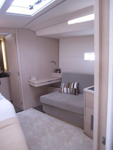 Modern interior of 2024 Jeanneau 55 yacht with cozy seating and natural light.