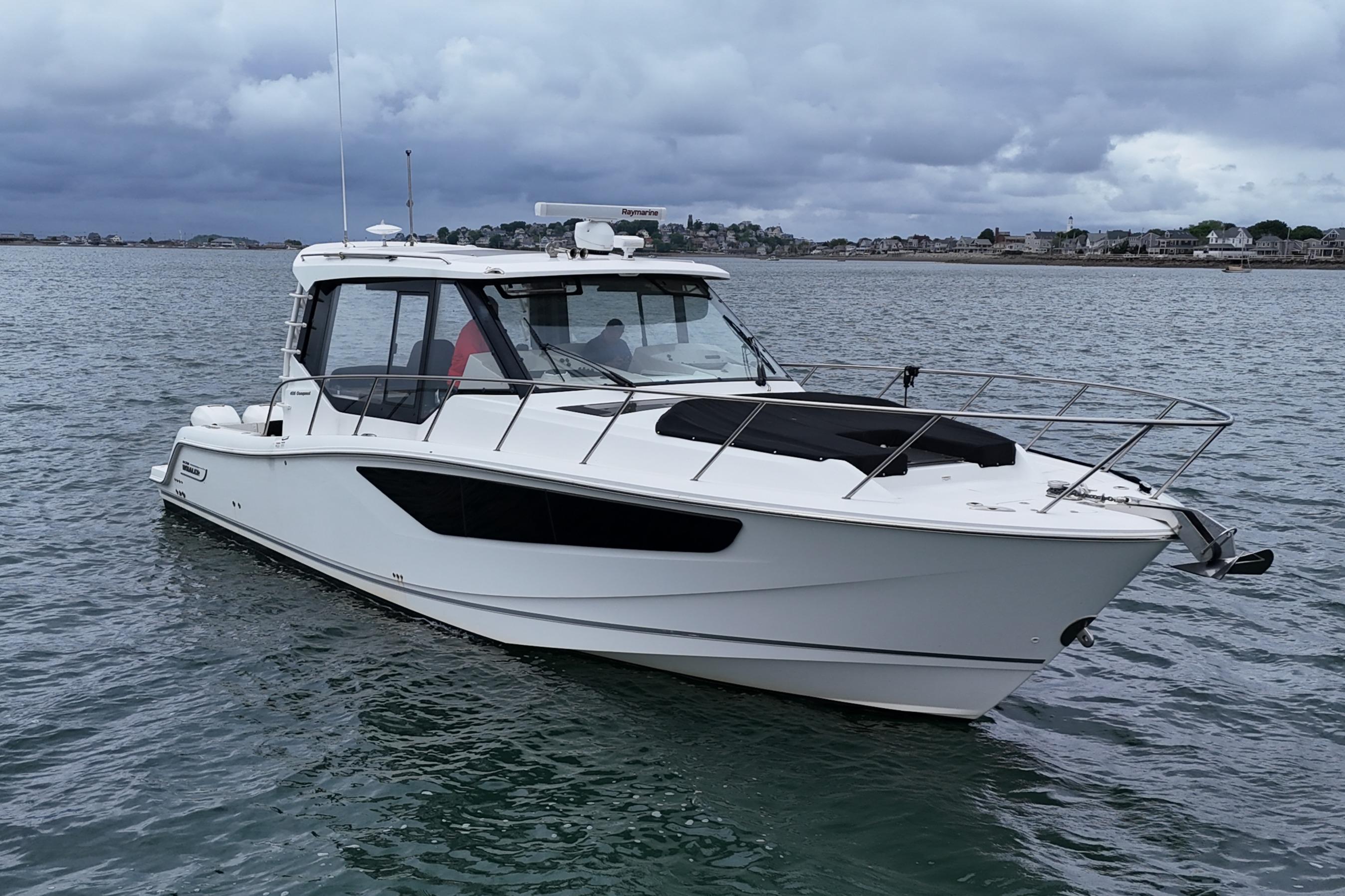2021 Boston Whaler 405 Conquest boat on calm water under cloudy skies.