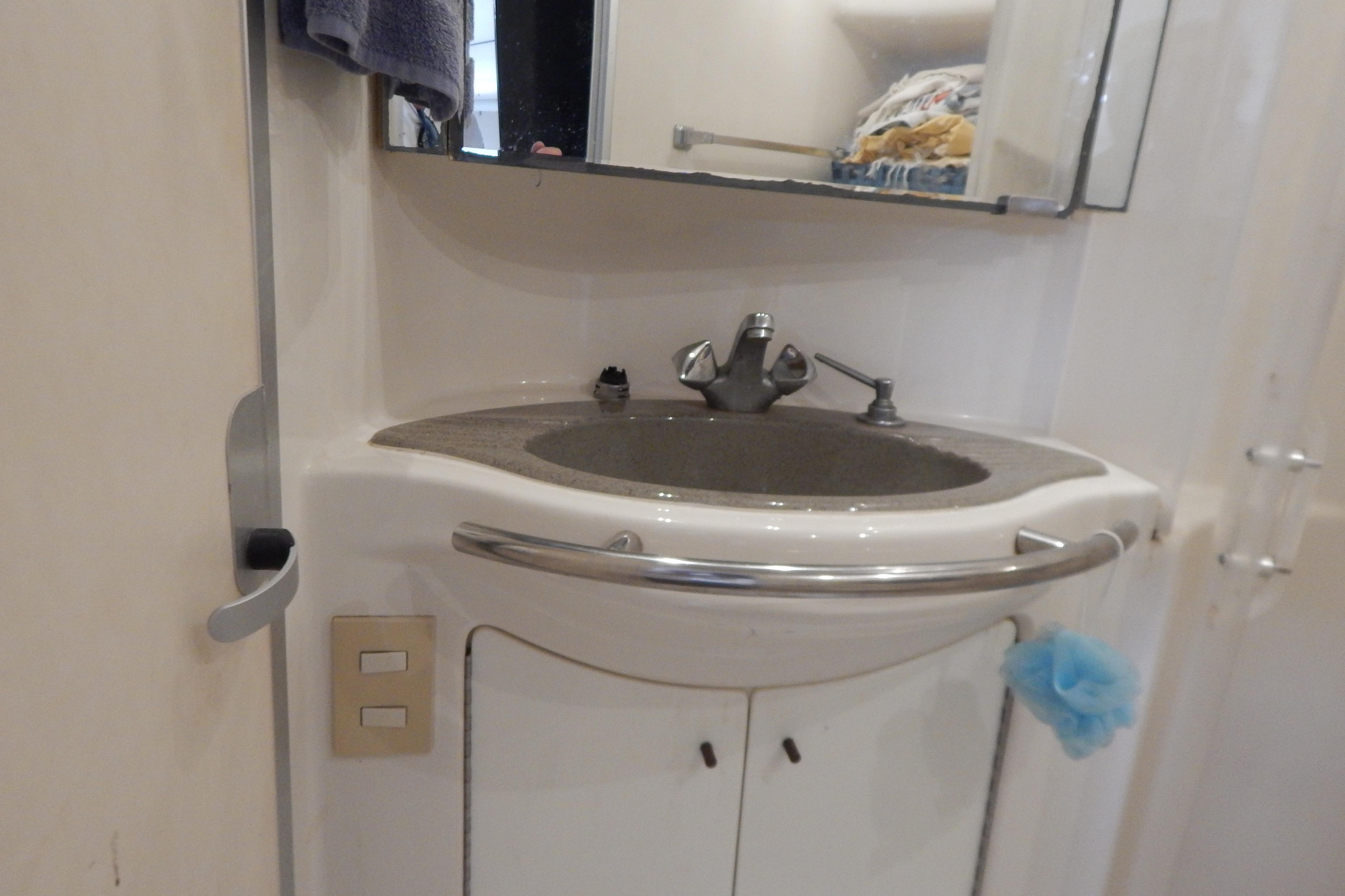 Bathroom sink area in a 1998 Magnum 4100 SCR yacht, featuring a mirror and storage.