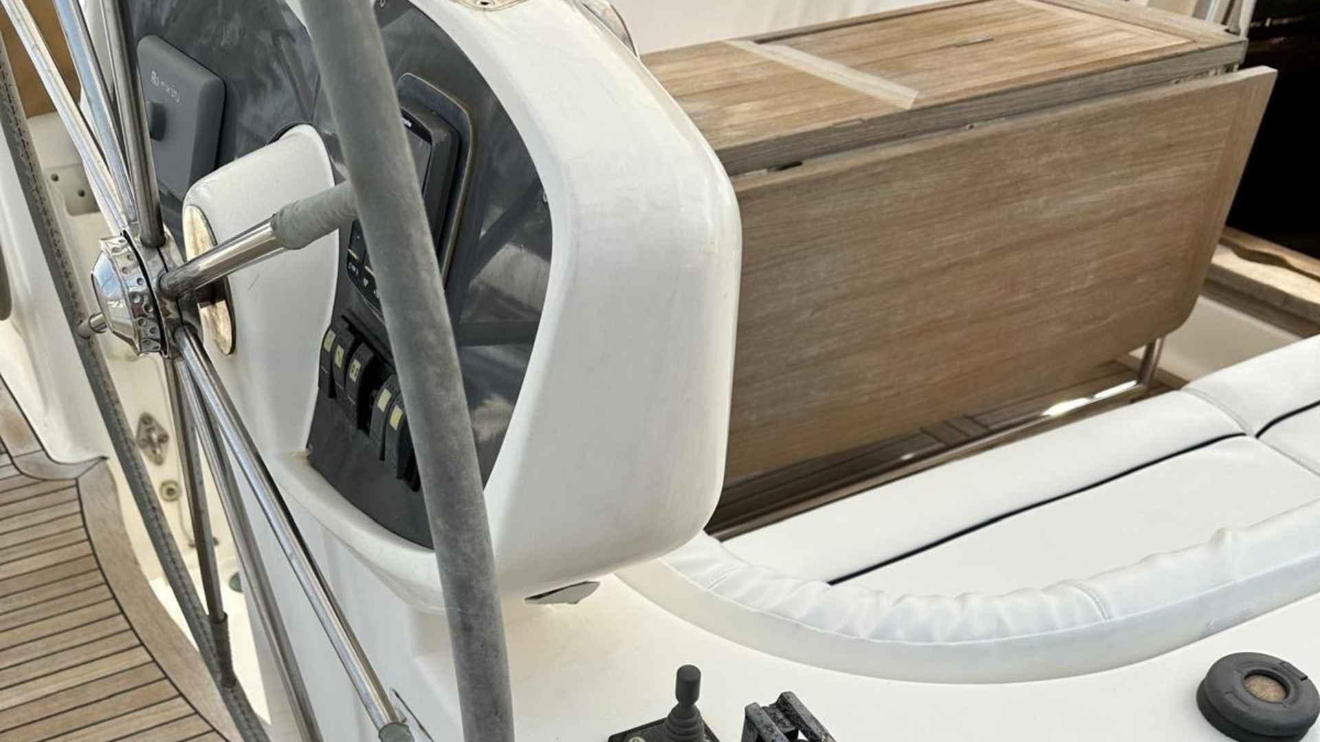 Steering wheel and controls of a 2004 Moody 64 yacht, featuring wooden and white elements.