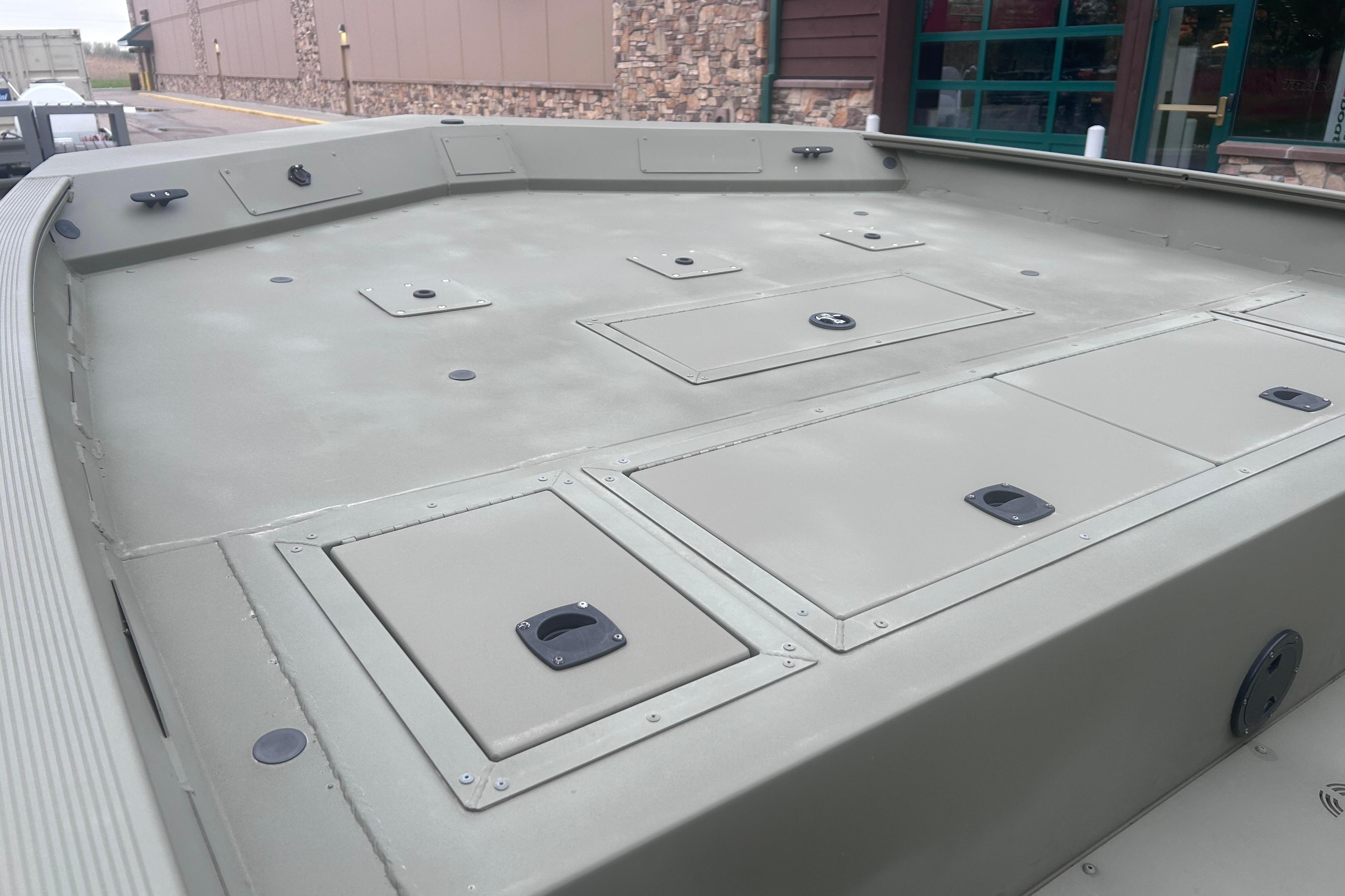 2024 Tracker Grizzly 2072 CC boat deck with storage compartments, displayed outdoors.