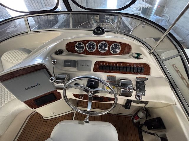 The cockpit of a 2004 Meridian 341 Sedan with wood trim and Garmin equipment.