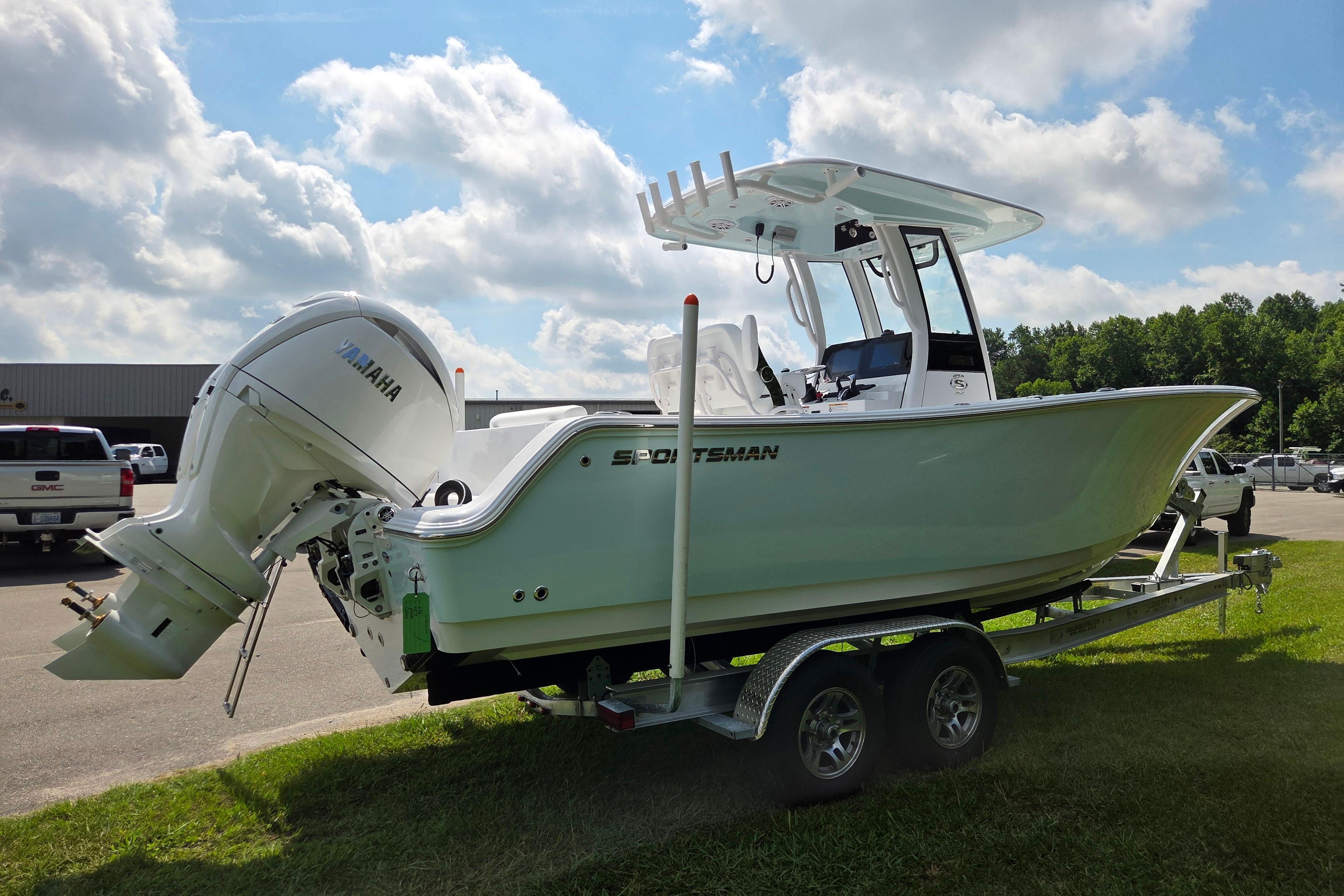 2026 Sportsman Open 252 Center Console boat on trailer, parked outdoors under a cloudy sky.
