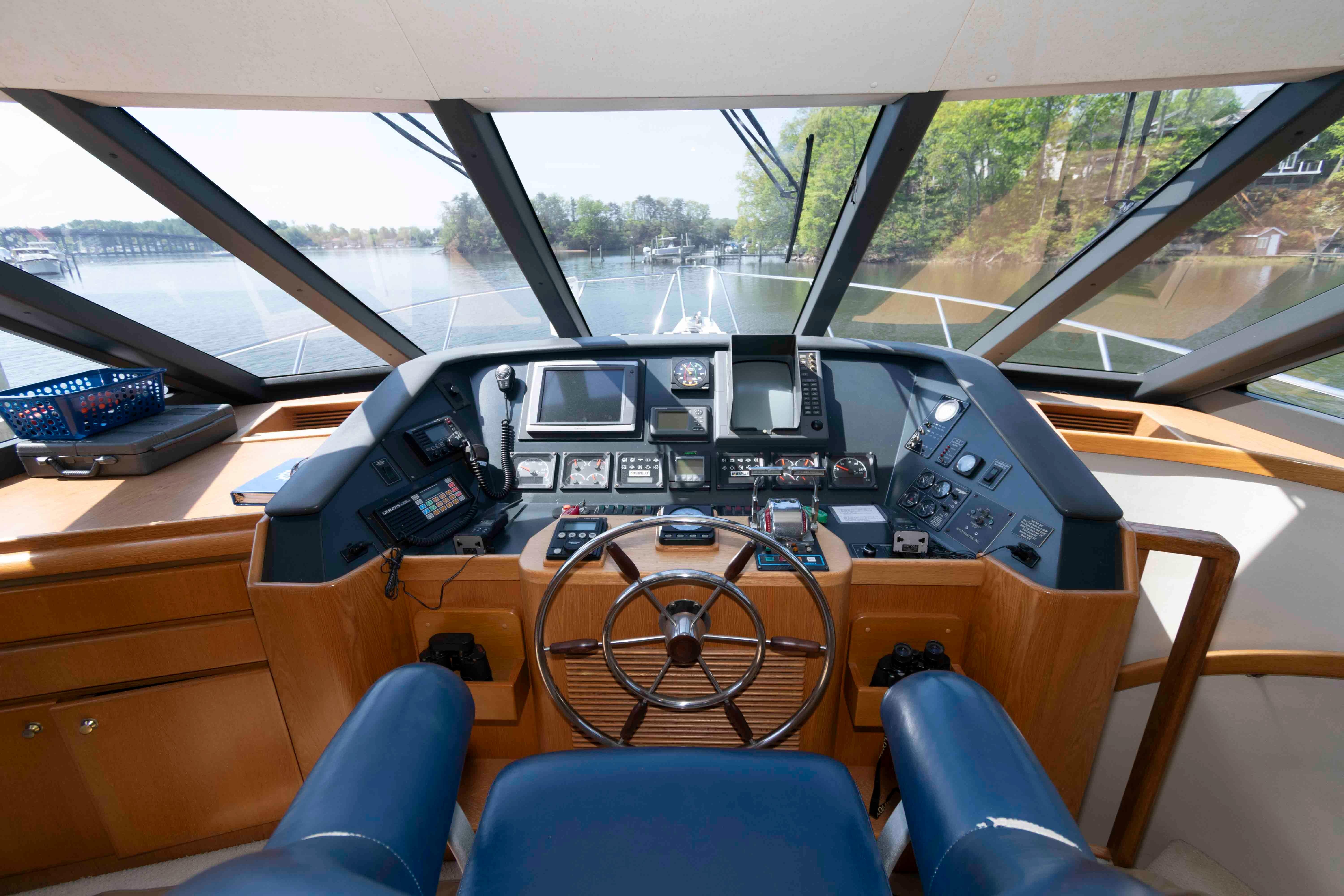 Pilothouse interior of 1999 West Bay 58 Sonship, featuring navigation controls and panoramic windows.