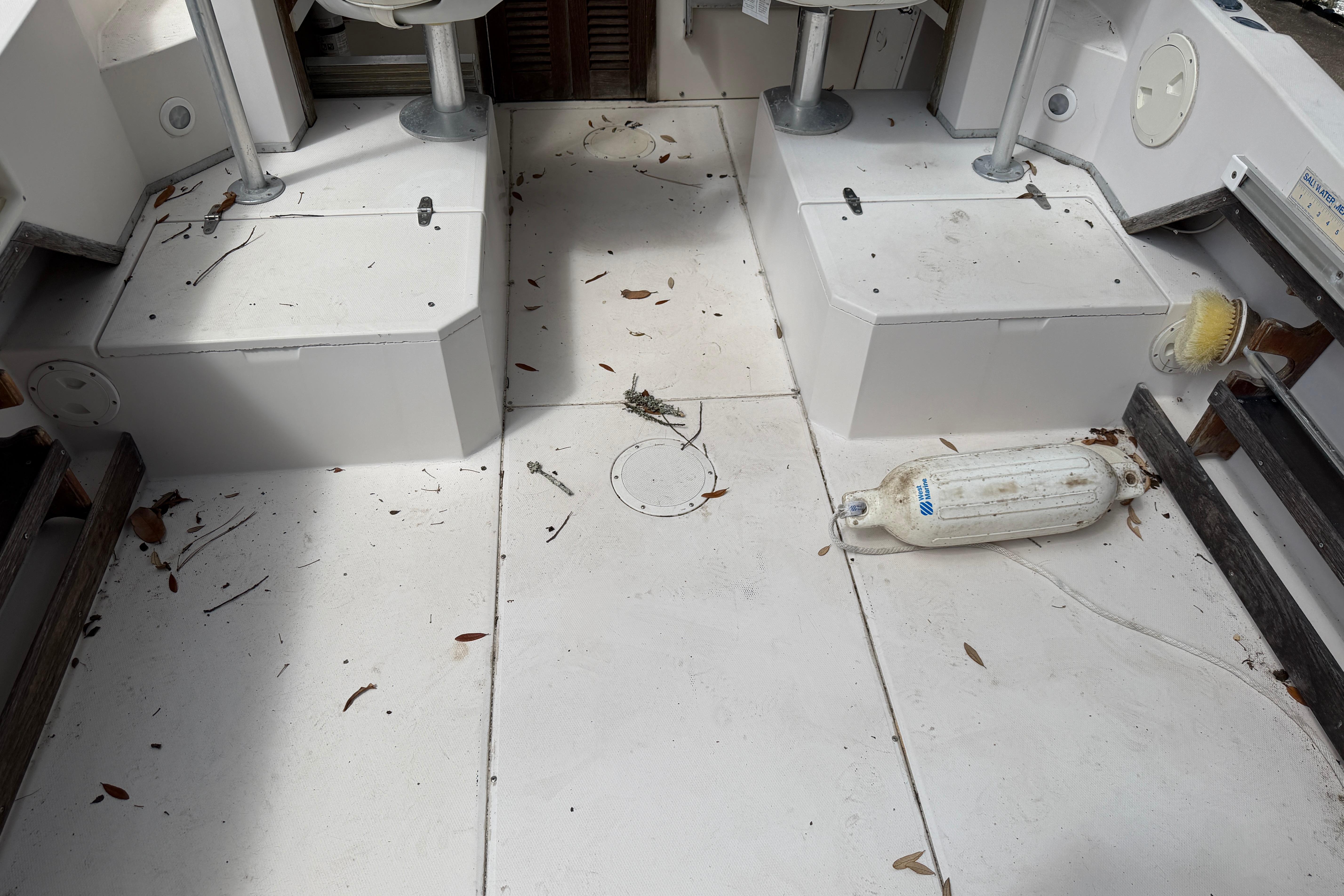 1987 Grady-White Seafarer 226 boat interior with leaves and debris on deck.