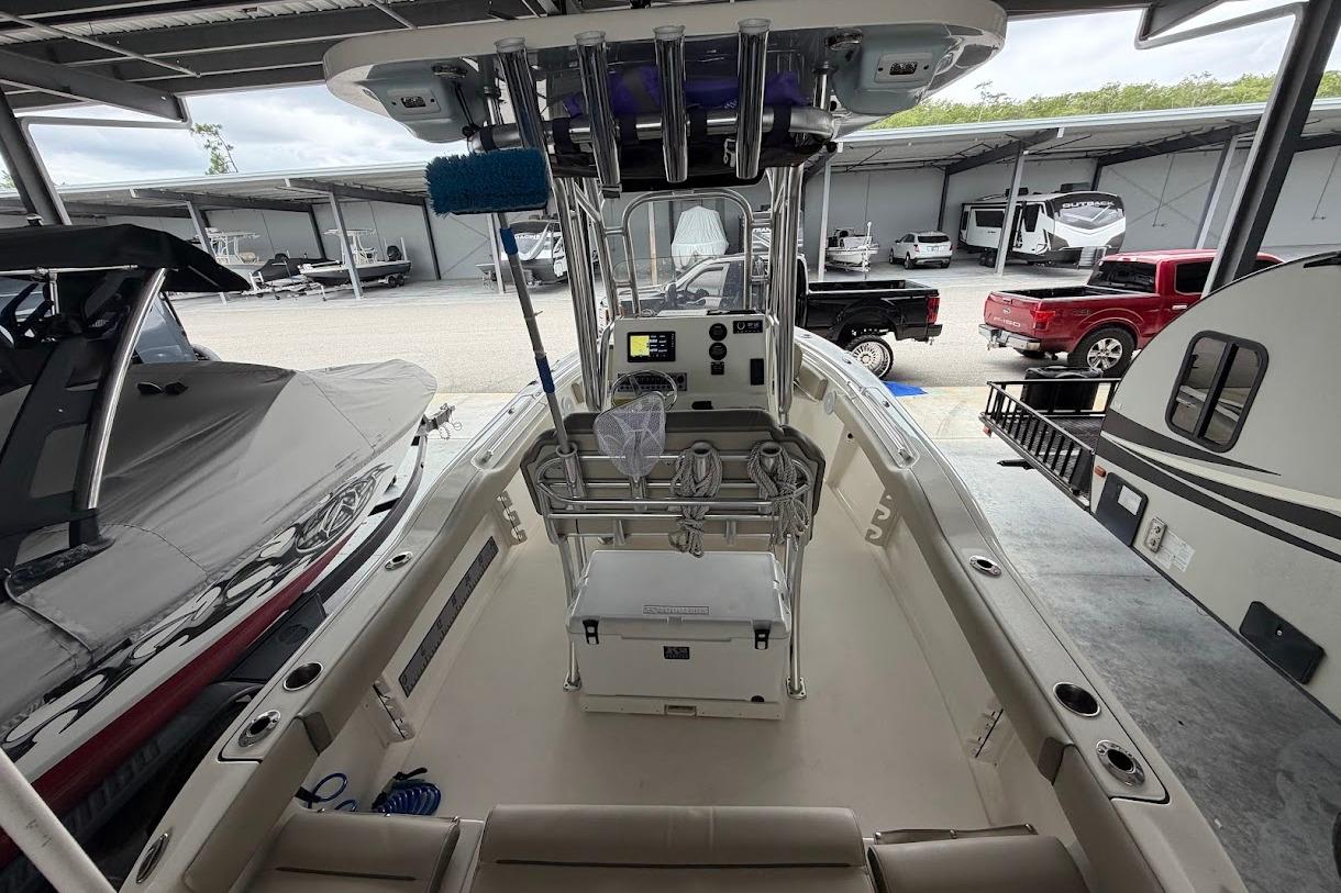 2024 Key West 219 FS boat interior, featuring console and seating, in a showroom setting.