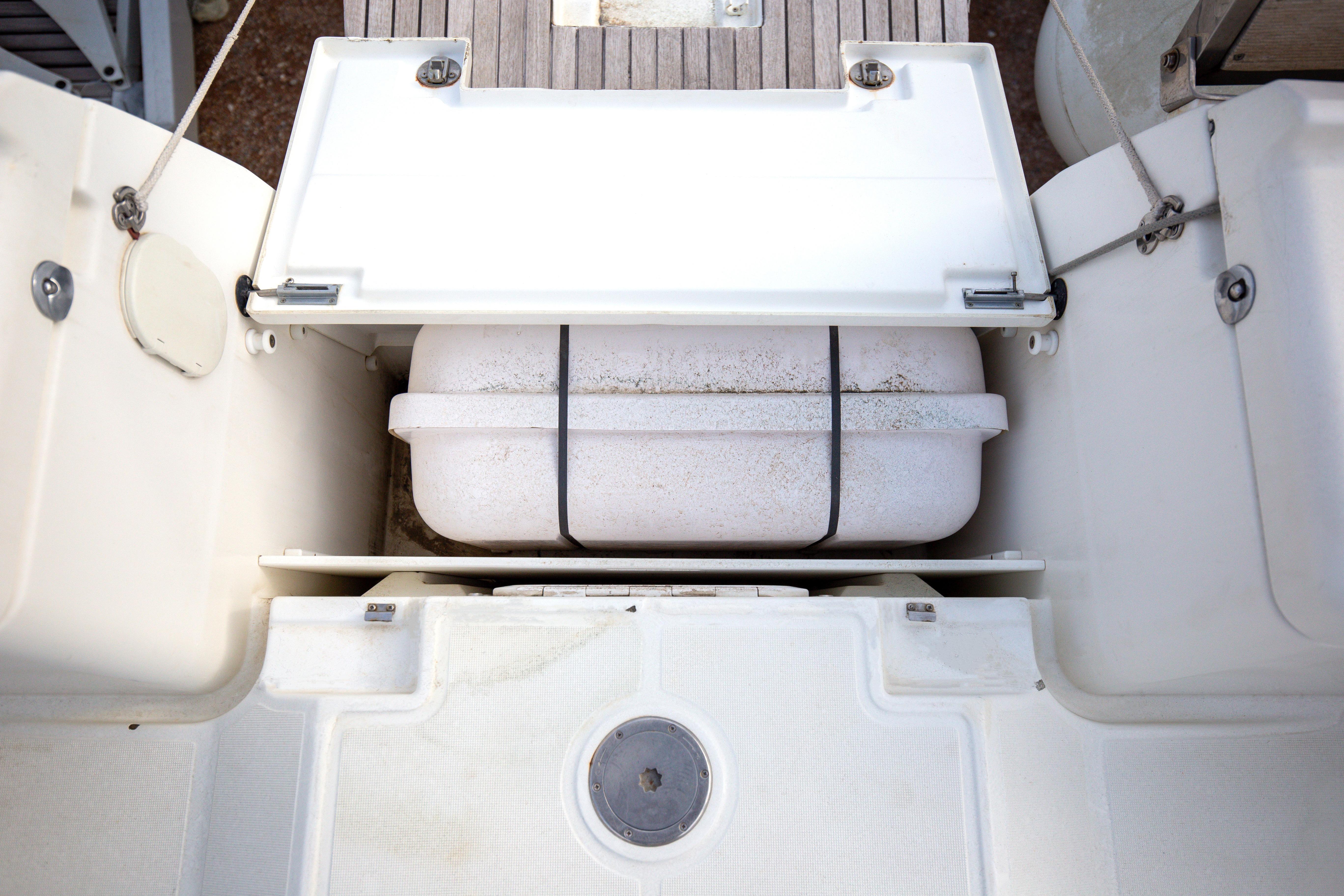 Storage compartment on a 2013 Jeanneau Sun Odyssey 439 sailboat, featuring a secured container.