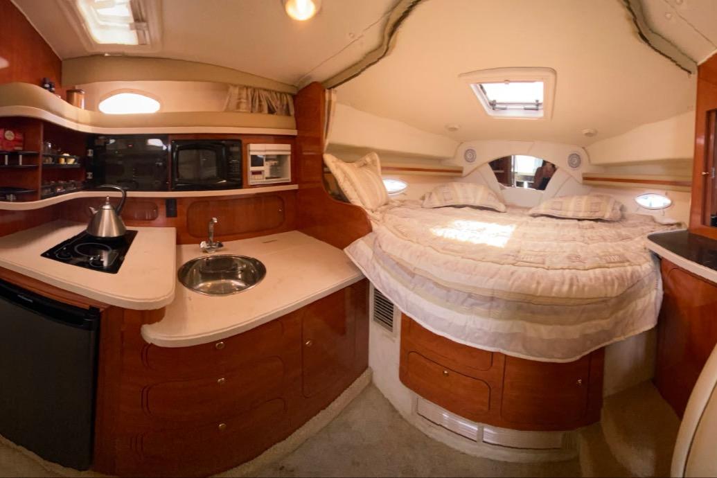 Interior of 2003 Rinker Fiesta Vee 342 yacht with cozy bed and kitchenette.