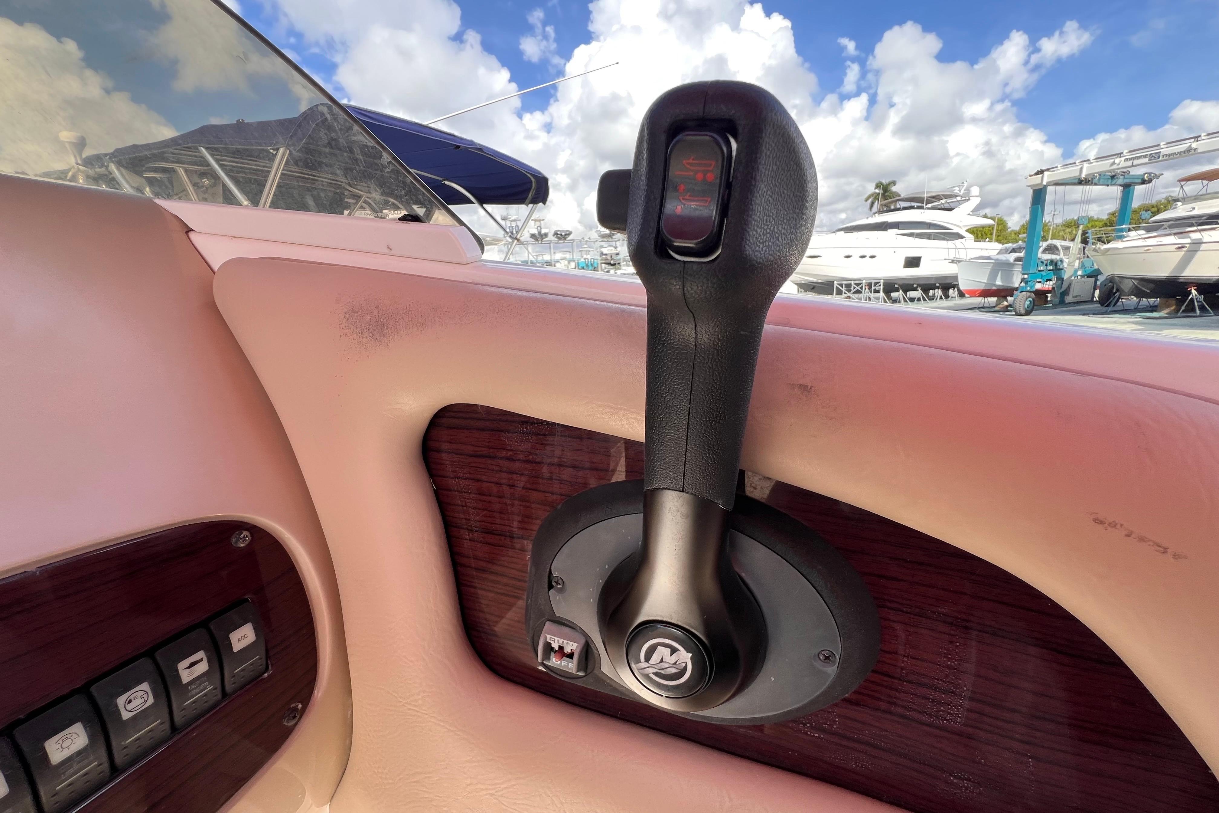 Throttle control of 2002 Chaparral 232 Sunesta boat, with marina view in background.