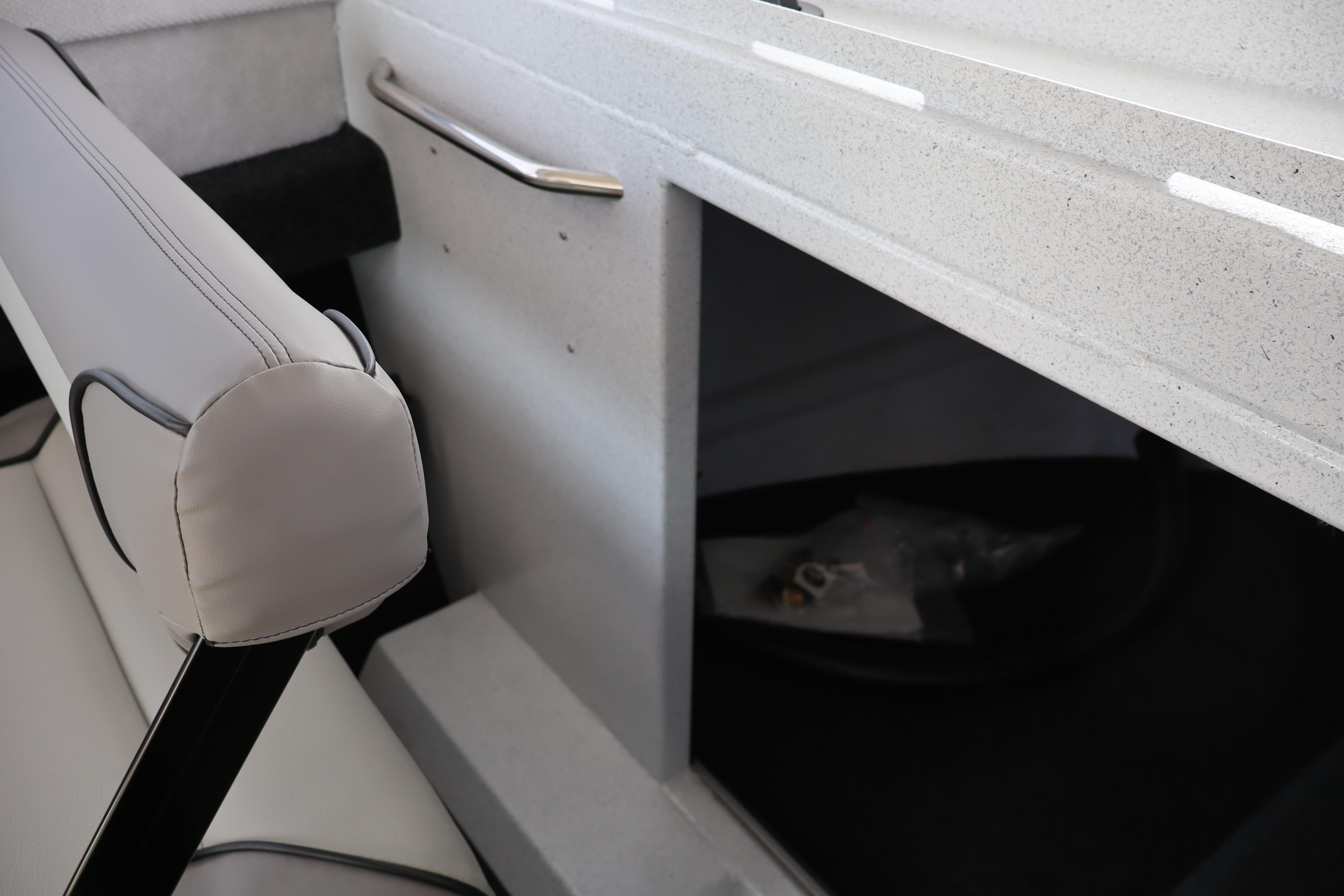 Interior of 2026 KingFisher 25 XAC boat, featuring seating and storage compartment.