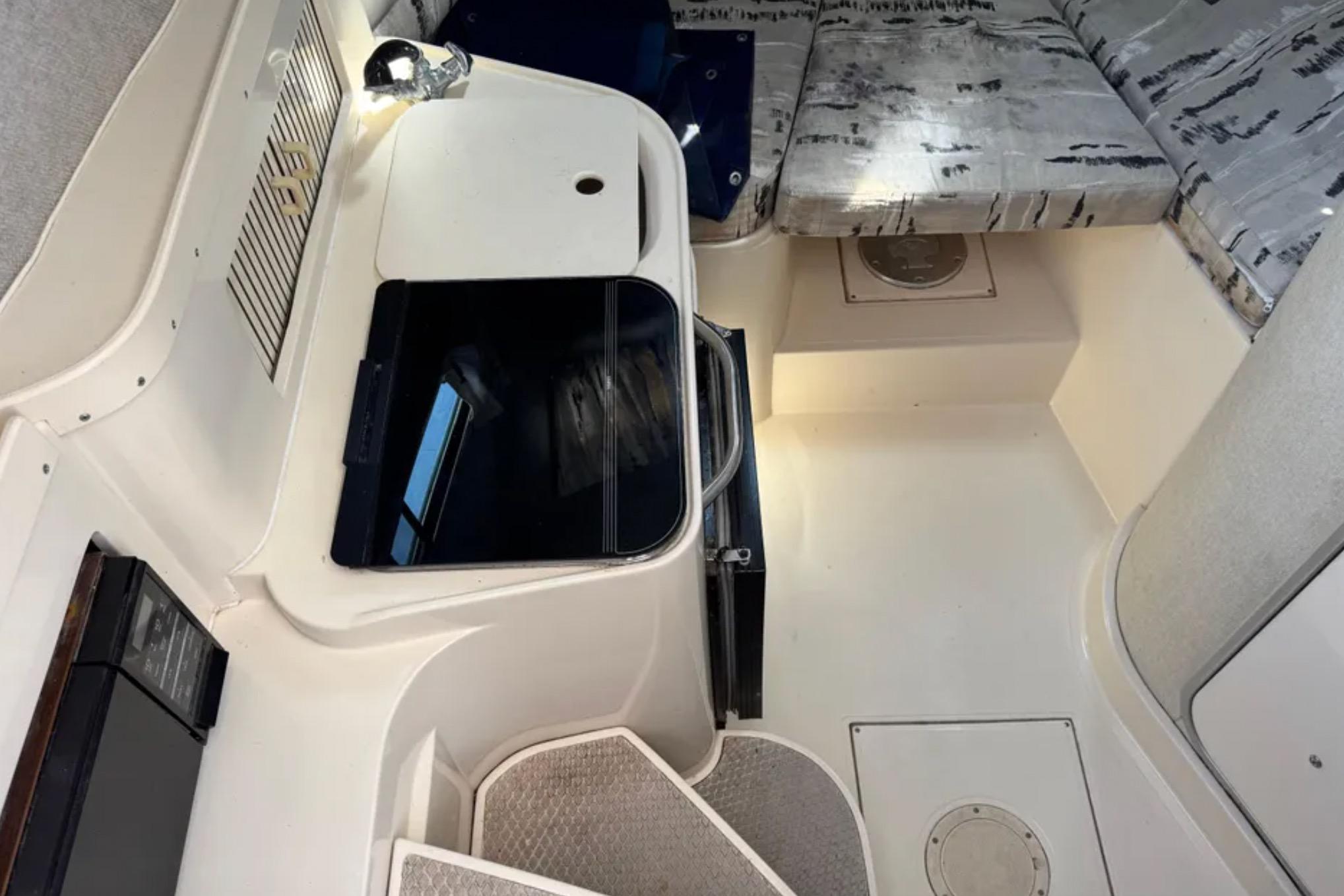 Interior cabin of a 1990 Grady-White Marlin 280 boat, featuring seating and storage.
