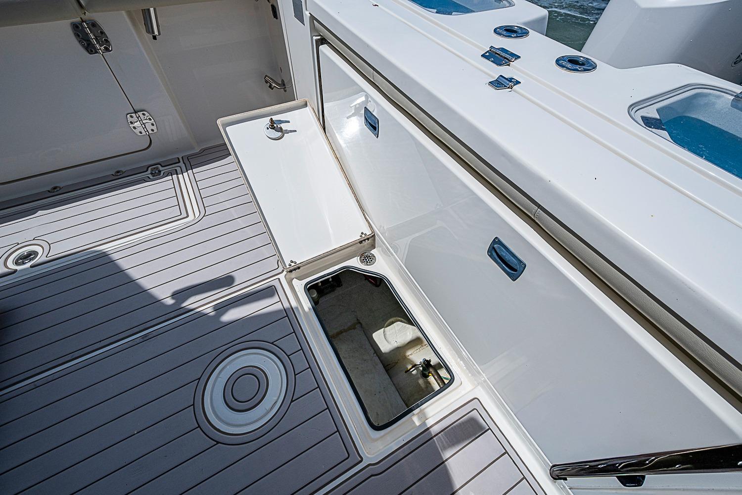 2019 Cobia 320 Center Console boat with open storage compartment on deck.
