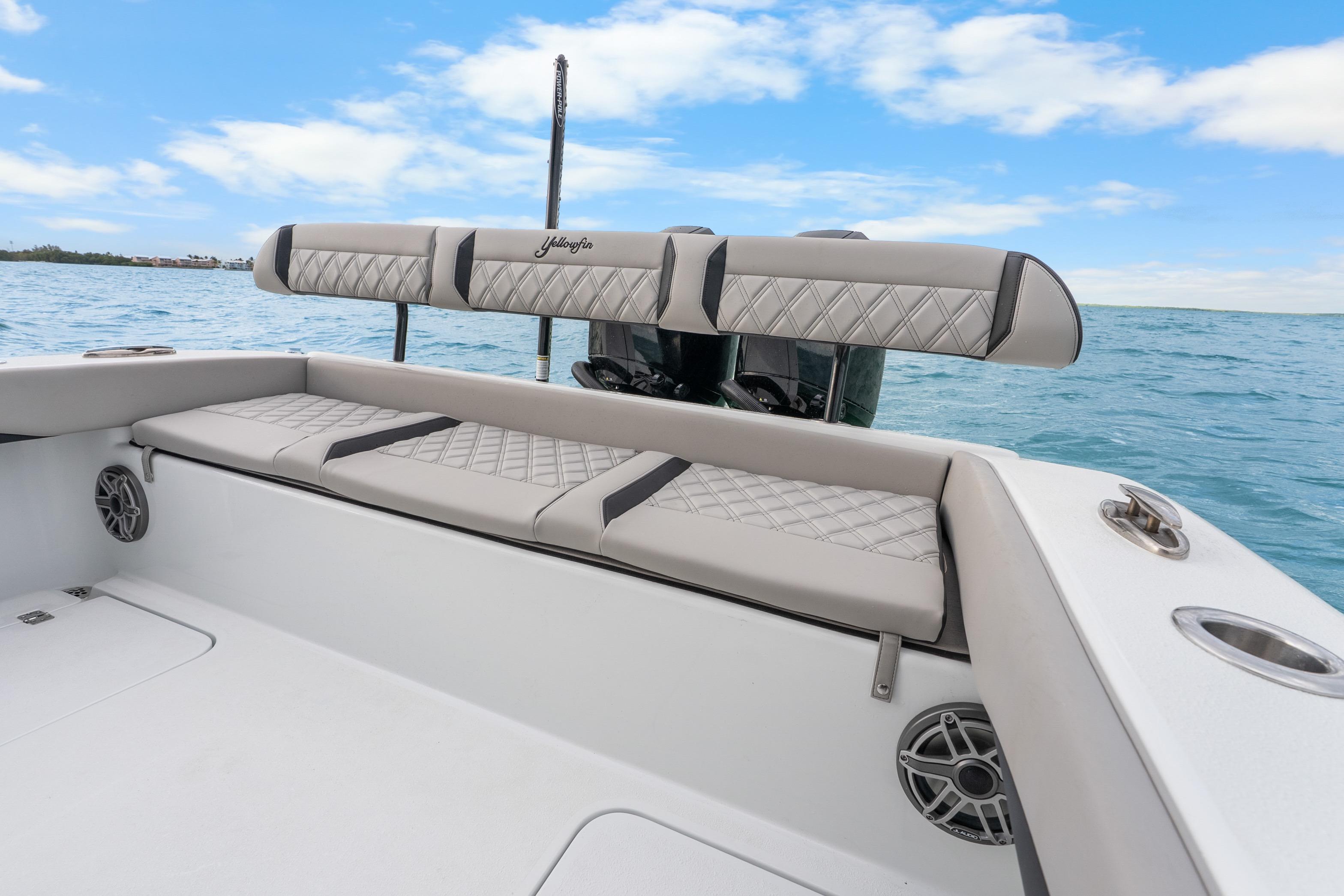 2025 Yellowfin 26 Hybrid boat interior with cushioned seating and ocean backdrop.