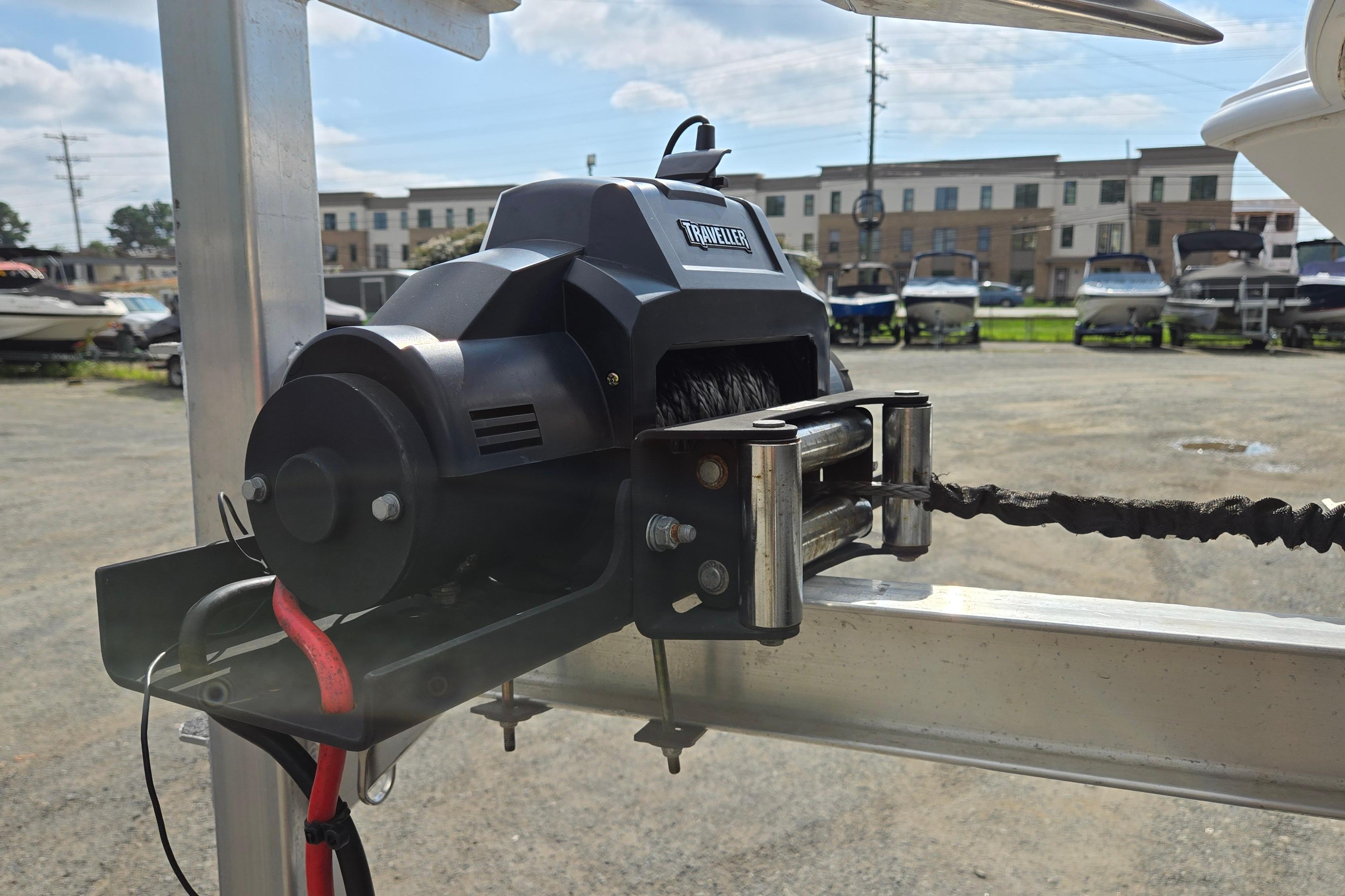 Electric boat winch on trailer, Twin Vee 240 DC GF, 2020 model, in a marina setting.