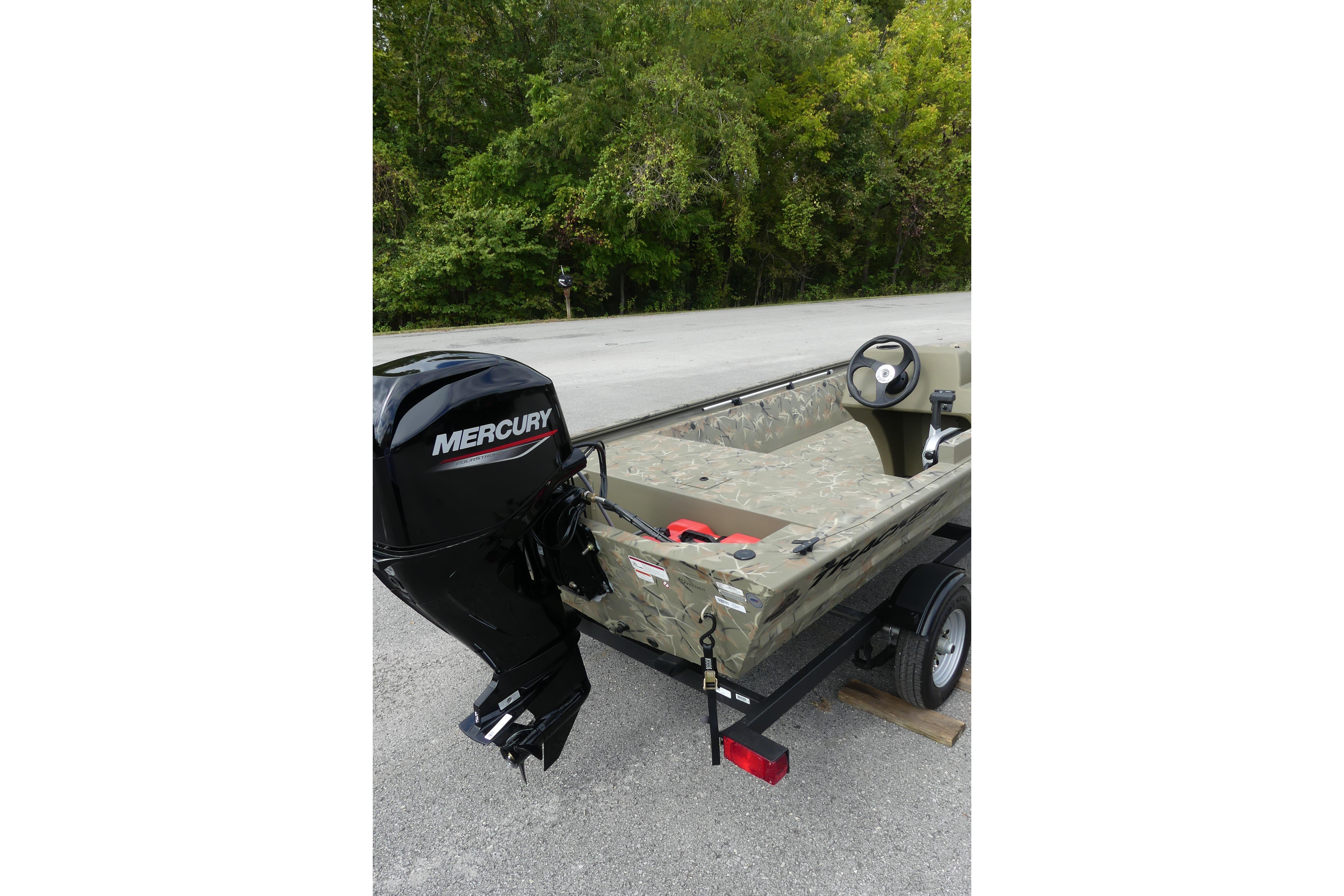 2025 Tracker Grizzly 1648 SC boat with Mercury engine on trailer, parked near trees.