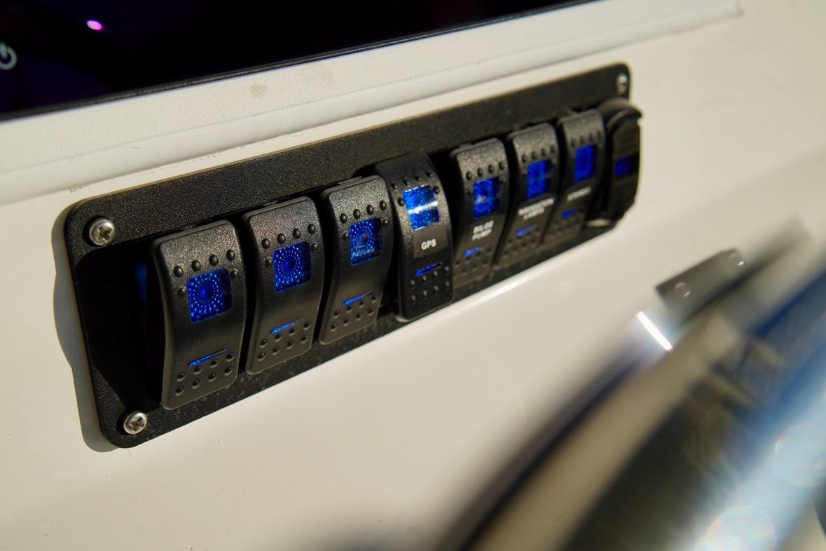 Control panel with illuminated switches on a 1970 Aquasport 222 Flatback boat.