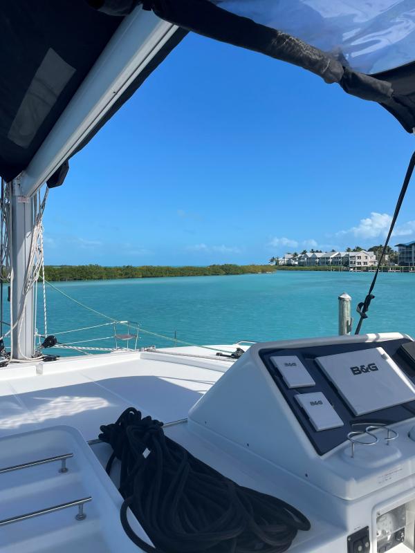 Lagoon 450 F catamaran, 2018 model, sailing in turquoise waters with clear blue sky.