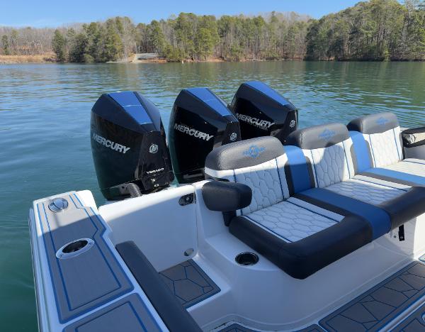 2024 Fountain 34 SC boat with triple Mercury engines on a serene lake.