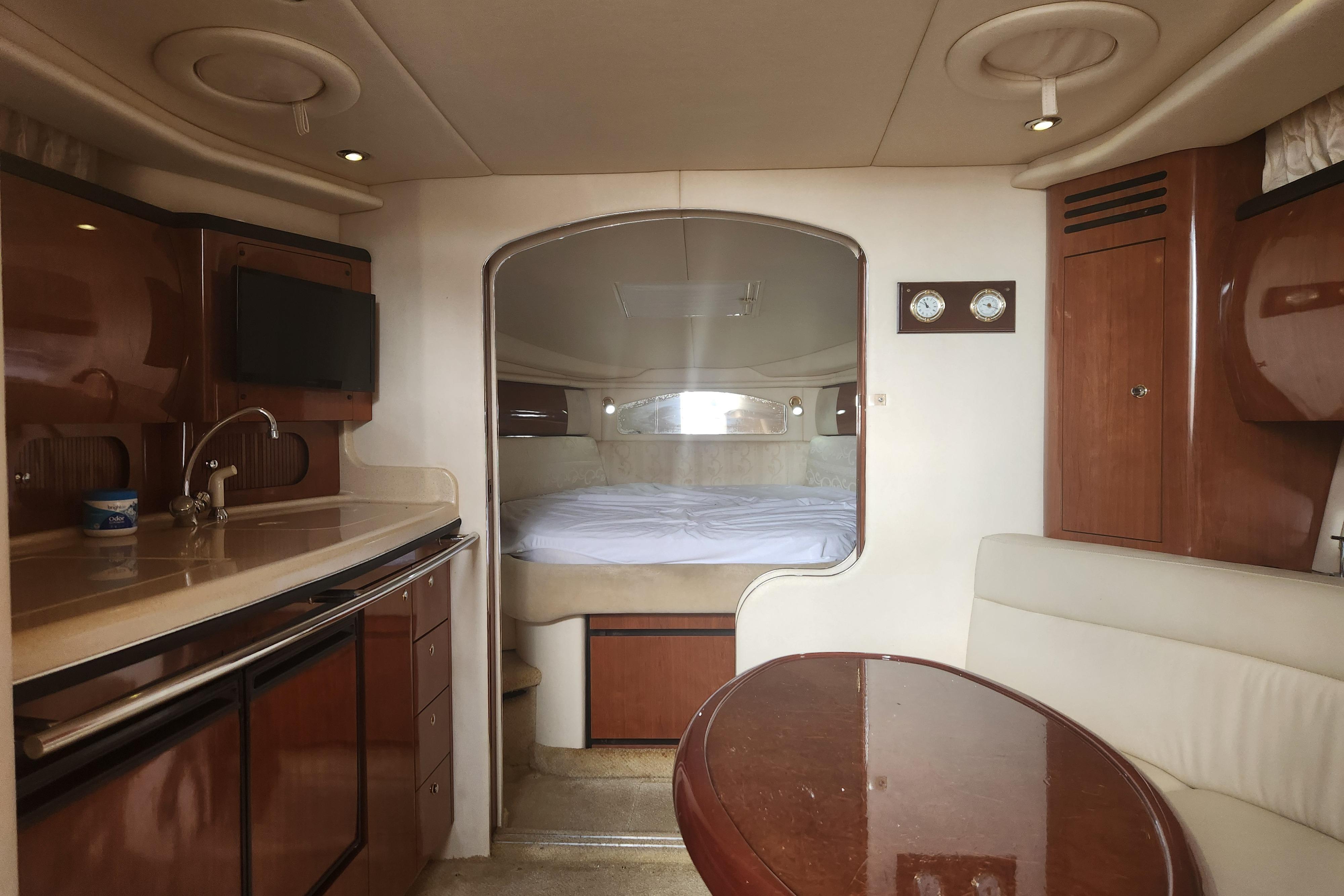 Interior of 2003 Sea Ray 360 Sundancer yacht with kitchenette and cozy sleeping area.