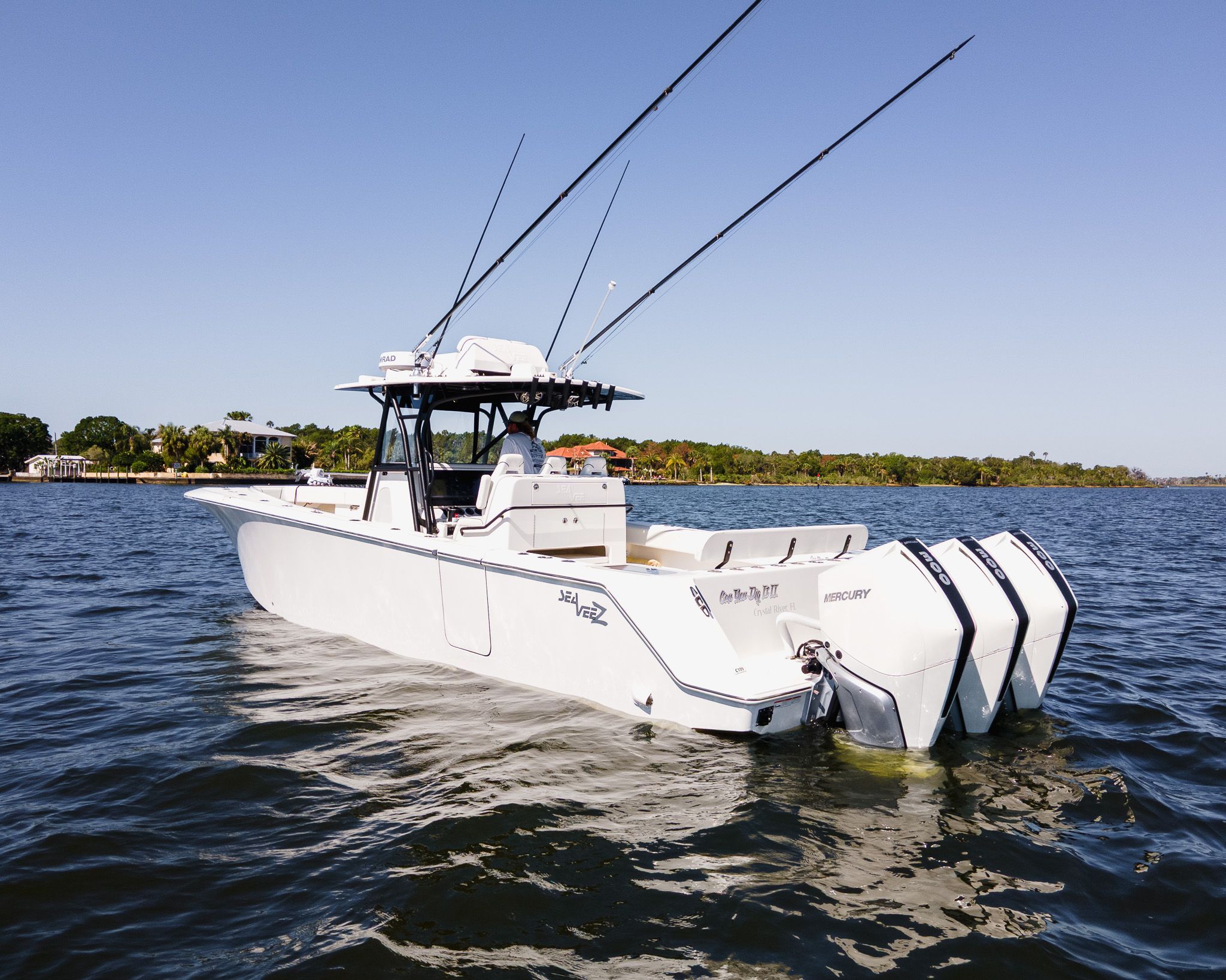 A white 2022 SeaVee 370Z boat with three outboard engines on calm water.