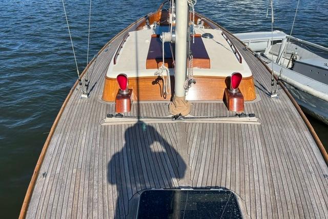 Deck view of a 2006 Morris 36 sailboat, featuring wooden finishes and moored on calm water.