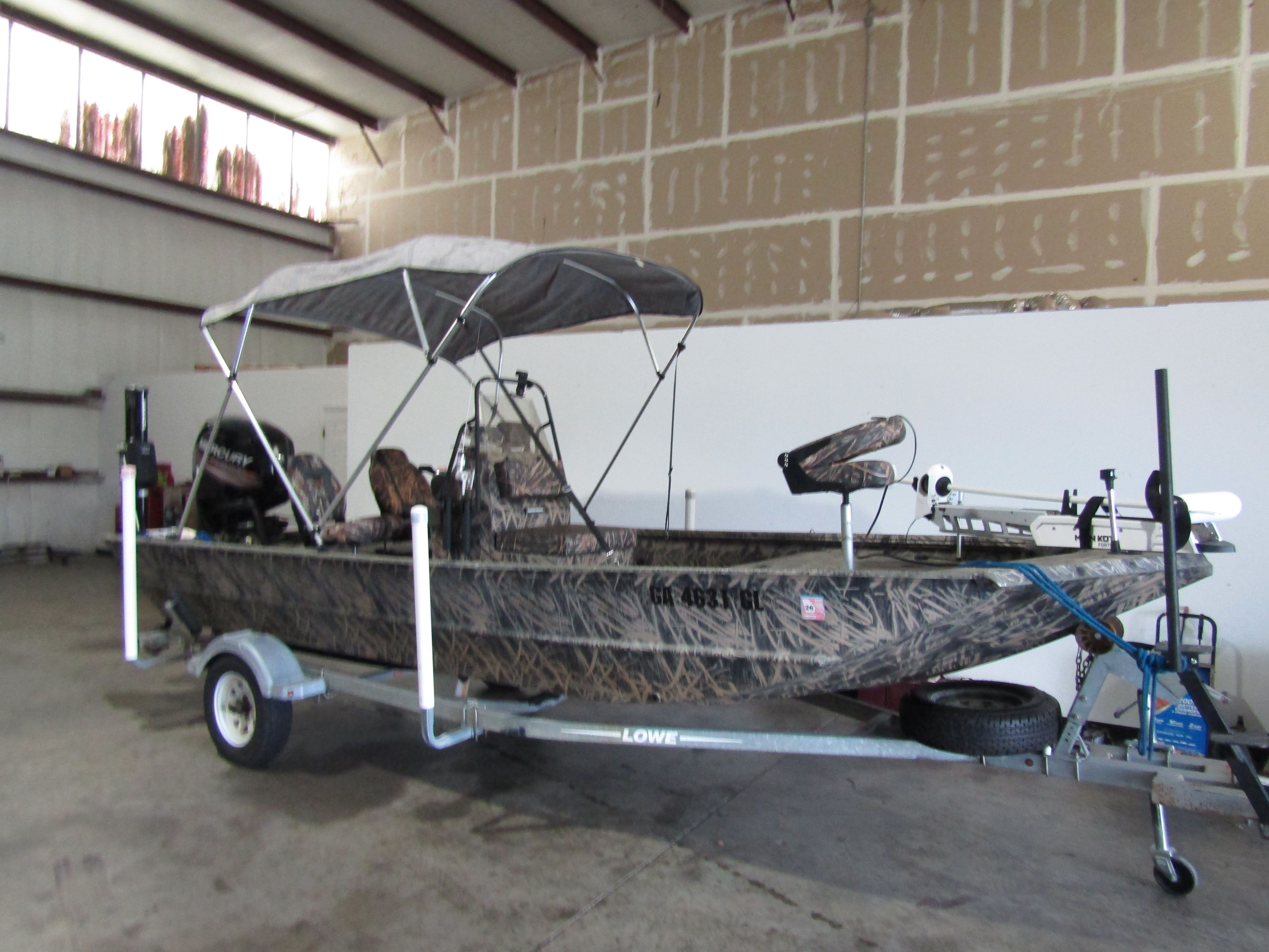 A 2016 Lowe 186 boat on a trailer inside a warehouse.