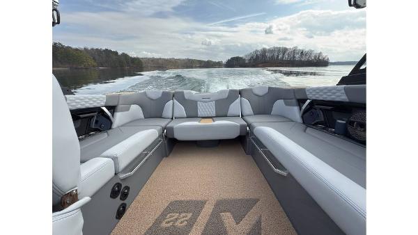 2023 MasterCraft XT22 boat interior with gray seating, cruising on a lake.