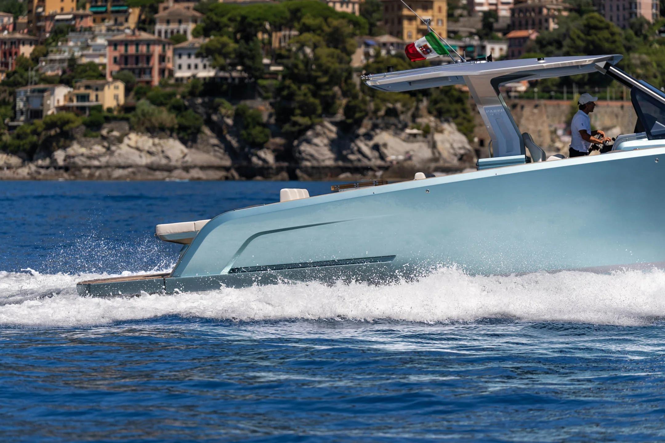 2026 Pardo Yachts P43 cruising on blue waters near a scenic coastal town.