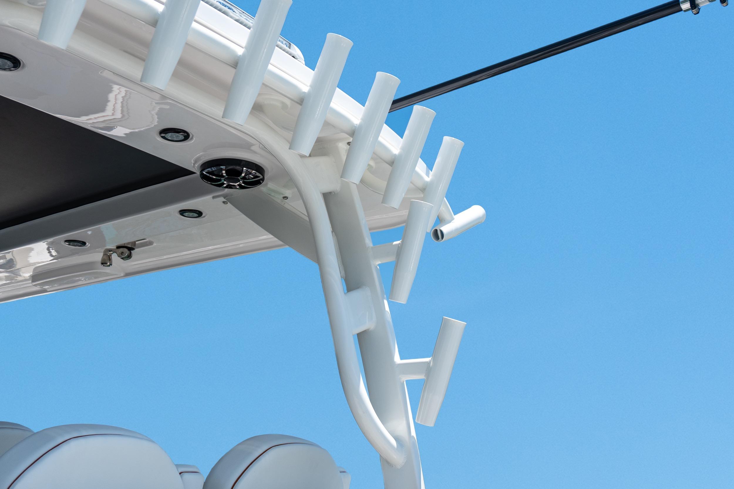 Close-up of 2026 Twin Vee 400 GFX2 CC boat's rod holders against a clear blue sky.