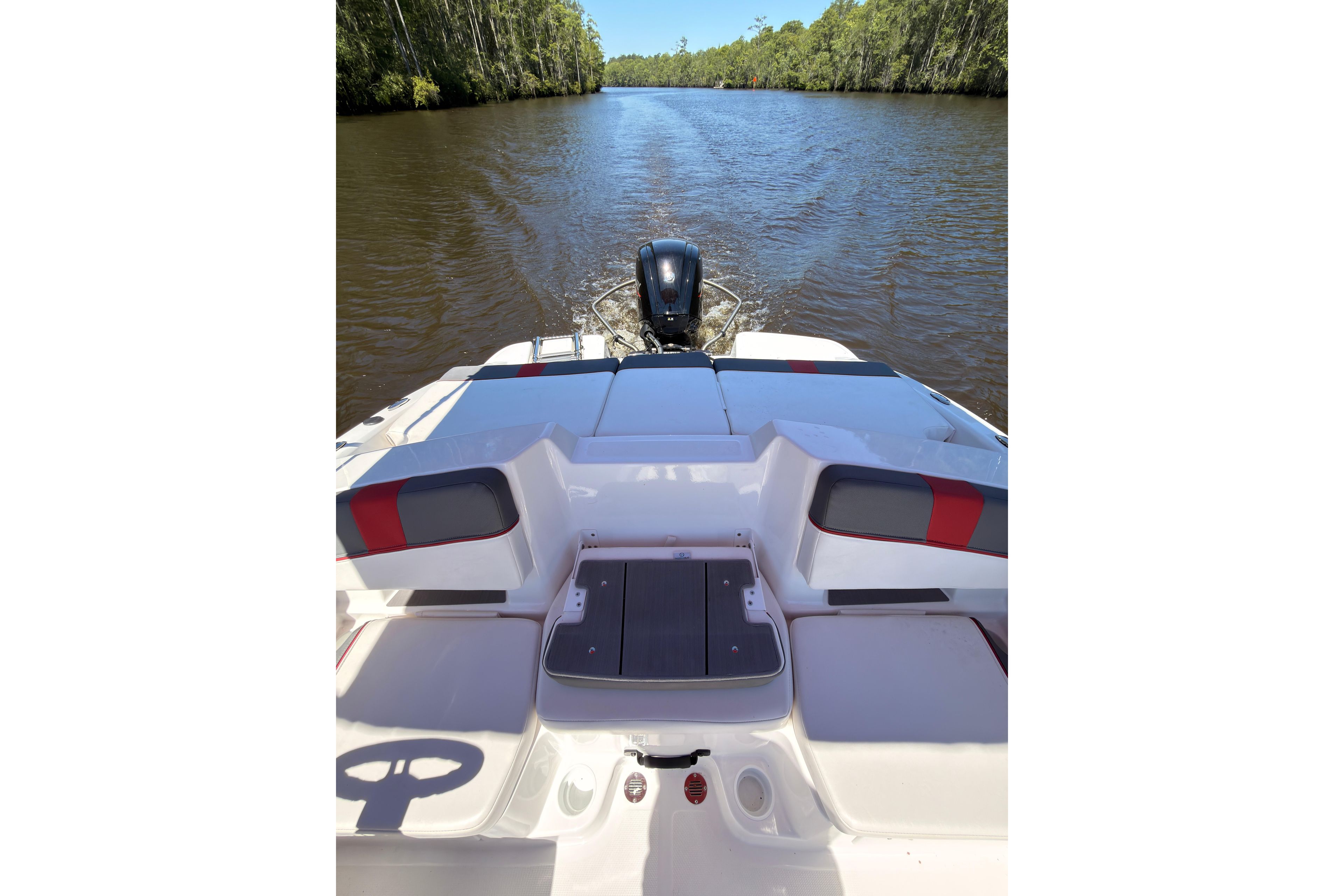 2022 Tahoe T18 boat cruising on a calm river surrounded by lush greenery.