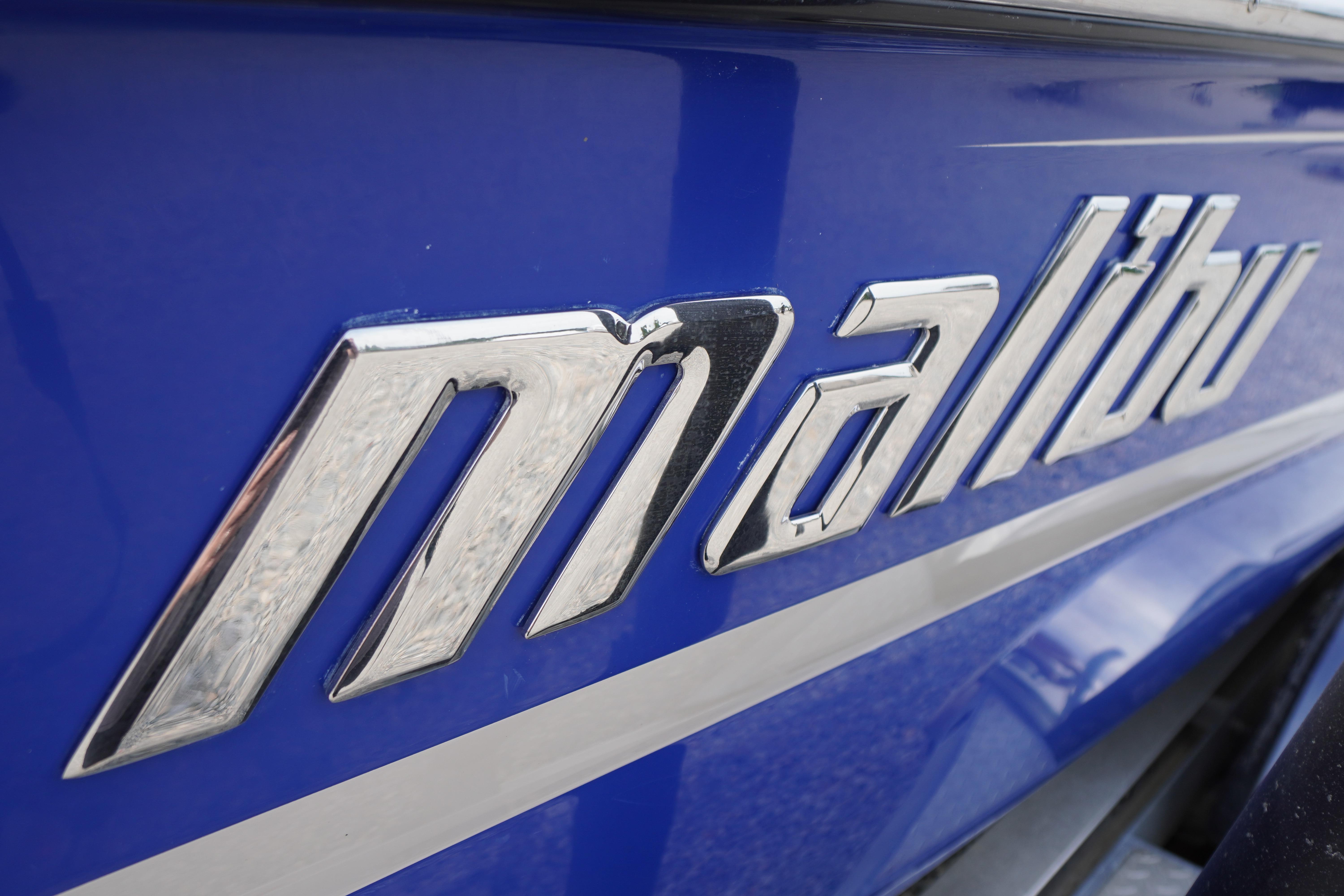 Close-up of 2011 Malibu Wakesetter 21 VLX logo on blue surface.