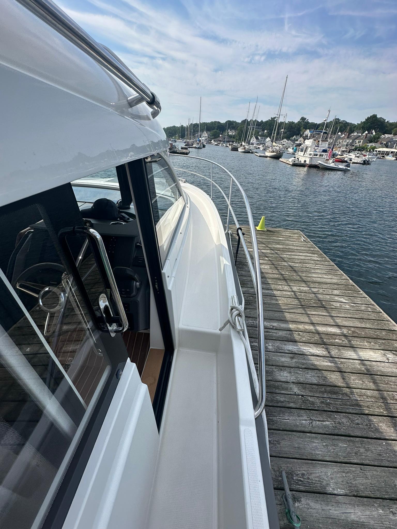 Nimbus 305 Coupe 2024 docked at a marina, showcasing sleek design and waterfront view.